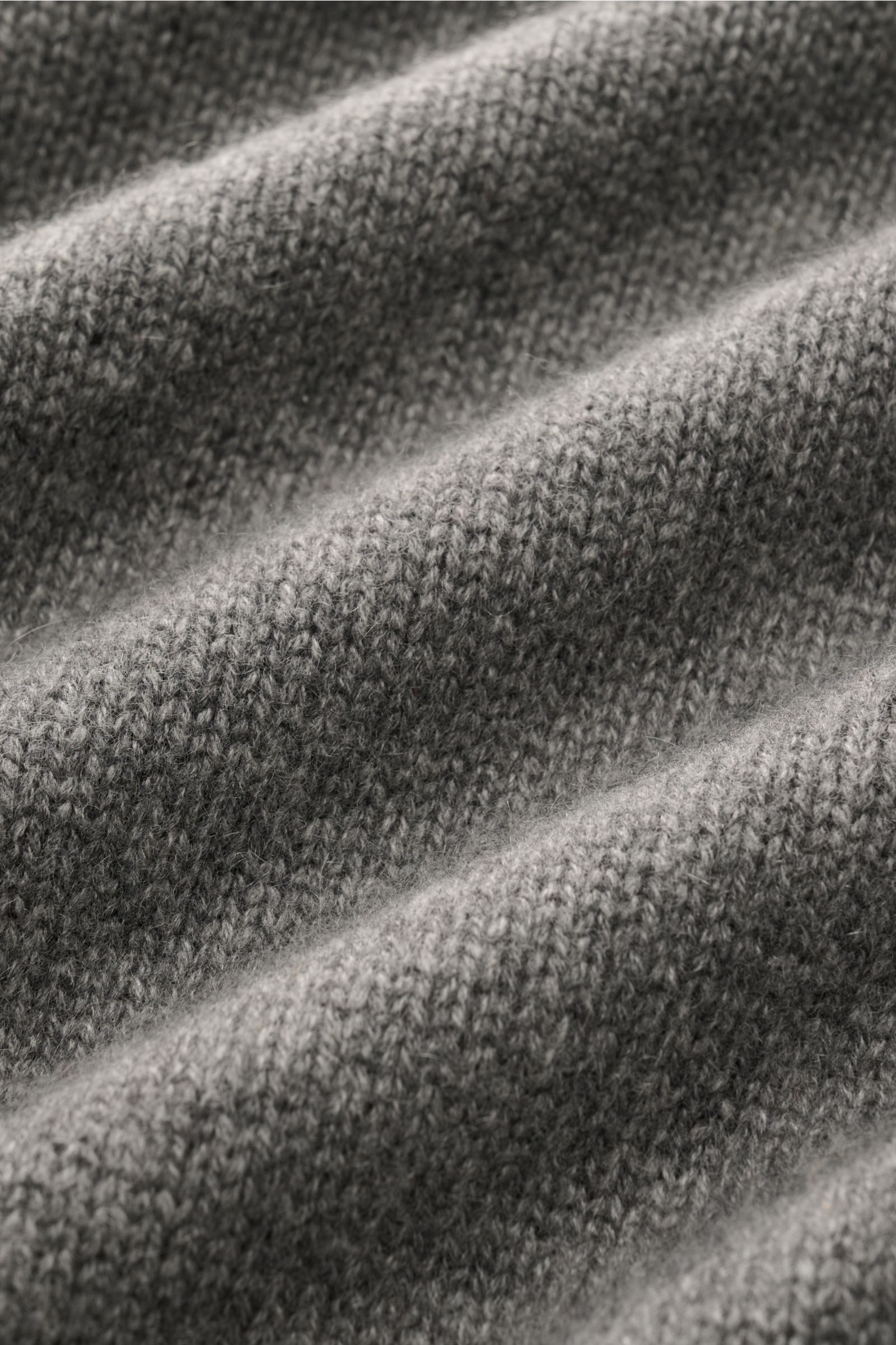 Nahaufnahme des weichen, mittelfeinen Strickbilds eines nachhaltigen Soft Goat Cashmere Rundhalspullover grau aus Slim Fit mit Rundhalsausschnitt und breiten Rippbündchen.