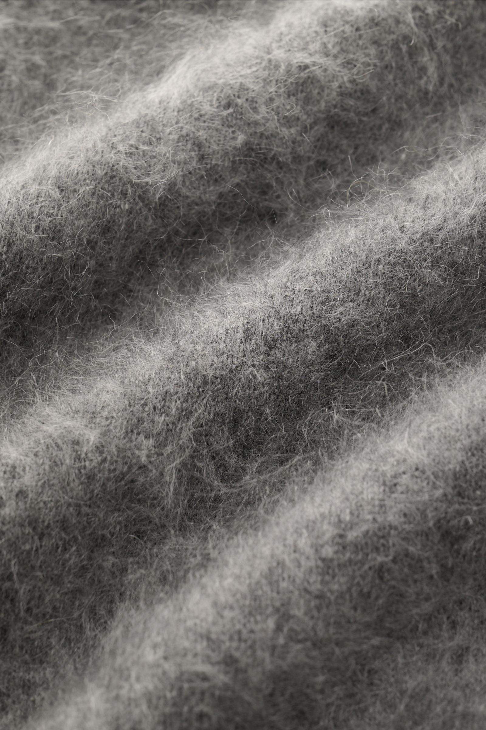 Soft Goat Cashmere Rundhalspullover grau meliert shown in close-up from above, highlighting the soft, brushed cashmere texture and fine knit. Luxus für jeden Tag: Das junge Label SOFT GOAT beweist mit diesem Rundhalspullover aus gebürstetem Cashmere, wie 