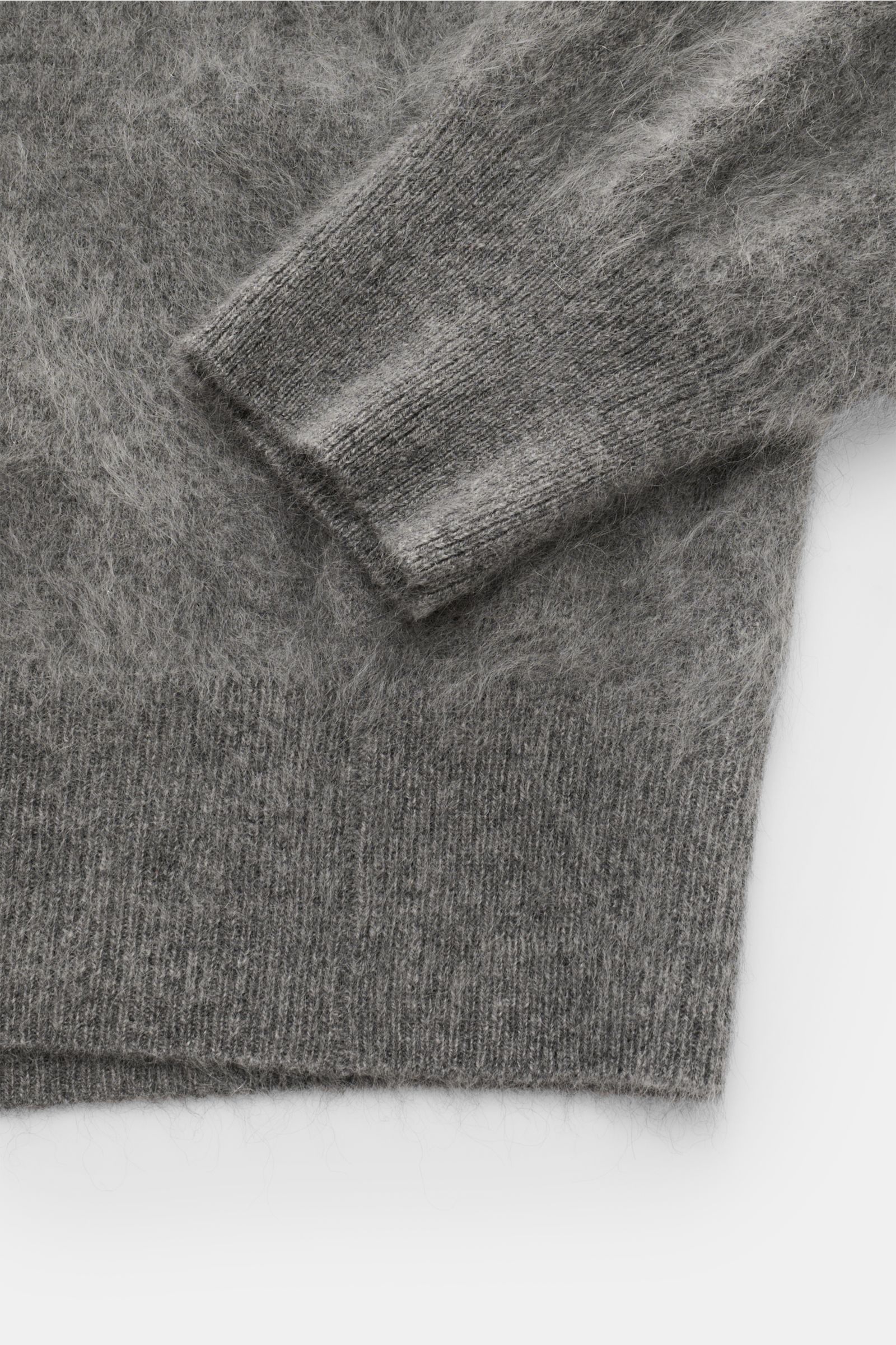 Close-up image from above showing the cuff and hem of the Soft Goat Cashmere Rundhalspullover grau meliert with brushed, voluminous texture, regular fit, round neckline, soft pure cashmere knit, and comfortable ribbed cuffs. Luxus für jeden Tag: Das junge