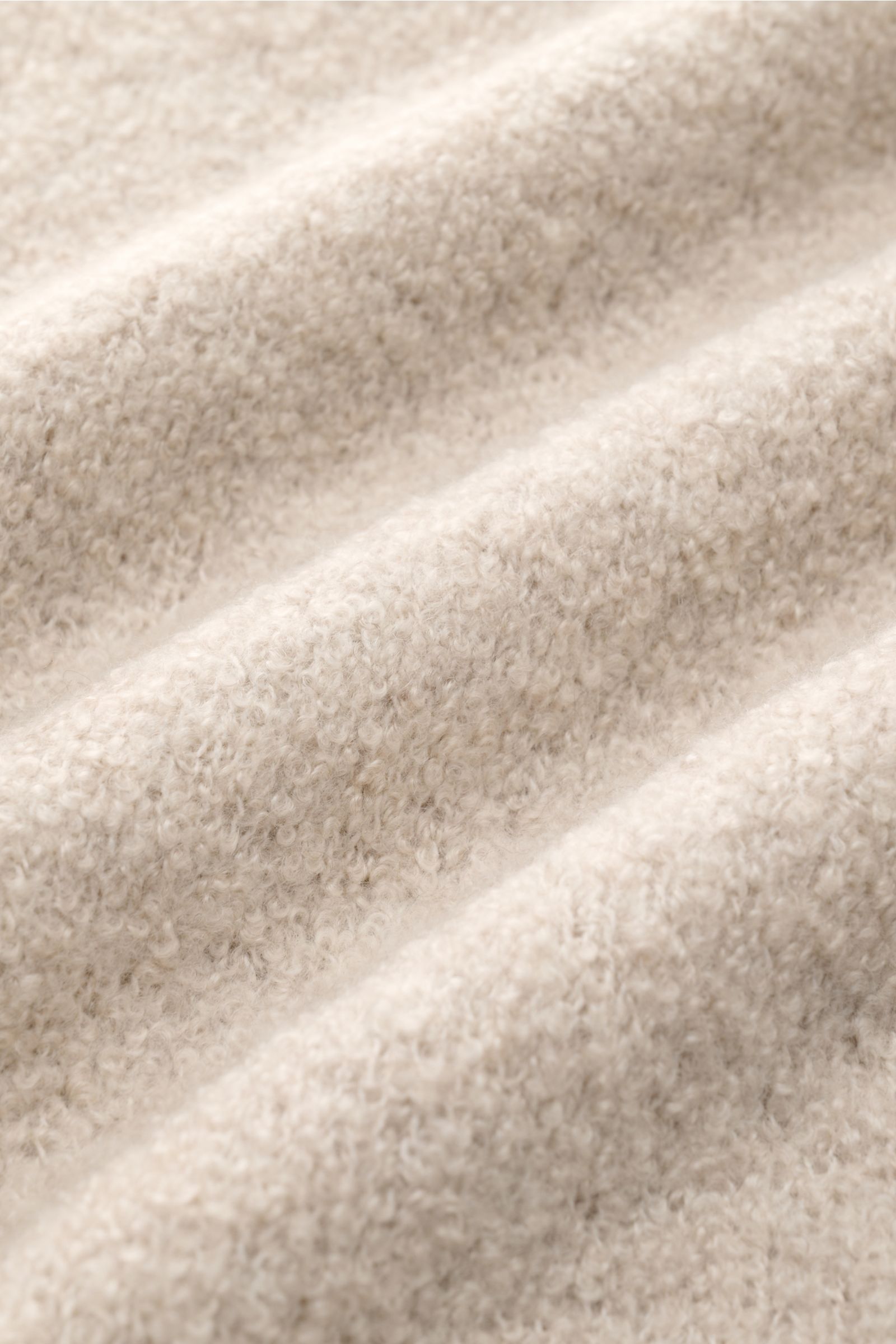 Nahaufnahme des Boucléstricks vom Soft Goat Rundhalspullover sand aus Cashmere-Mix, nachhaltig, mit weichem Griff und mittelfeinem Strickbild.