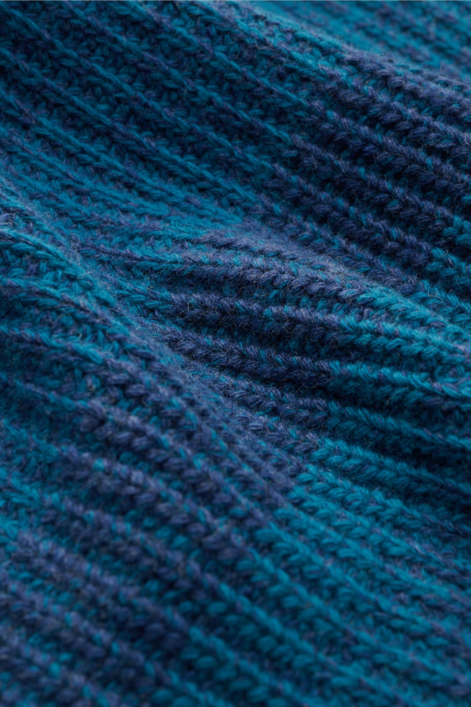 Nahaufnahme des grob gestrickten Barbour Rundhalspullover 'Saddle' türkis/dunkelblau gestreift mit weichem, voluminösem Wollstrick.