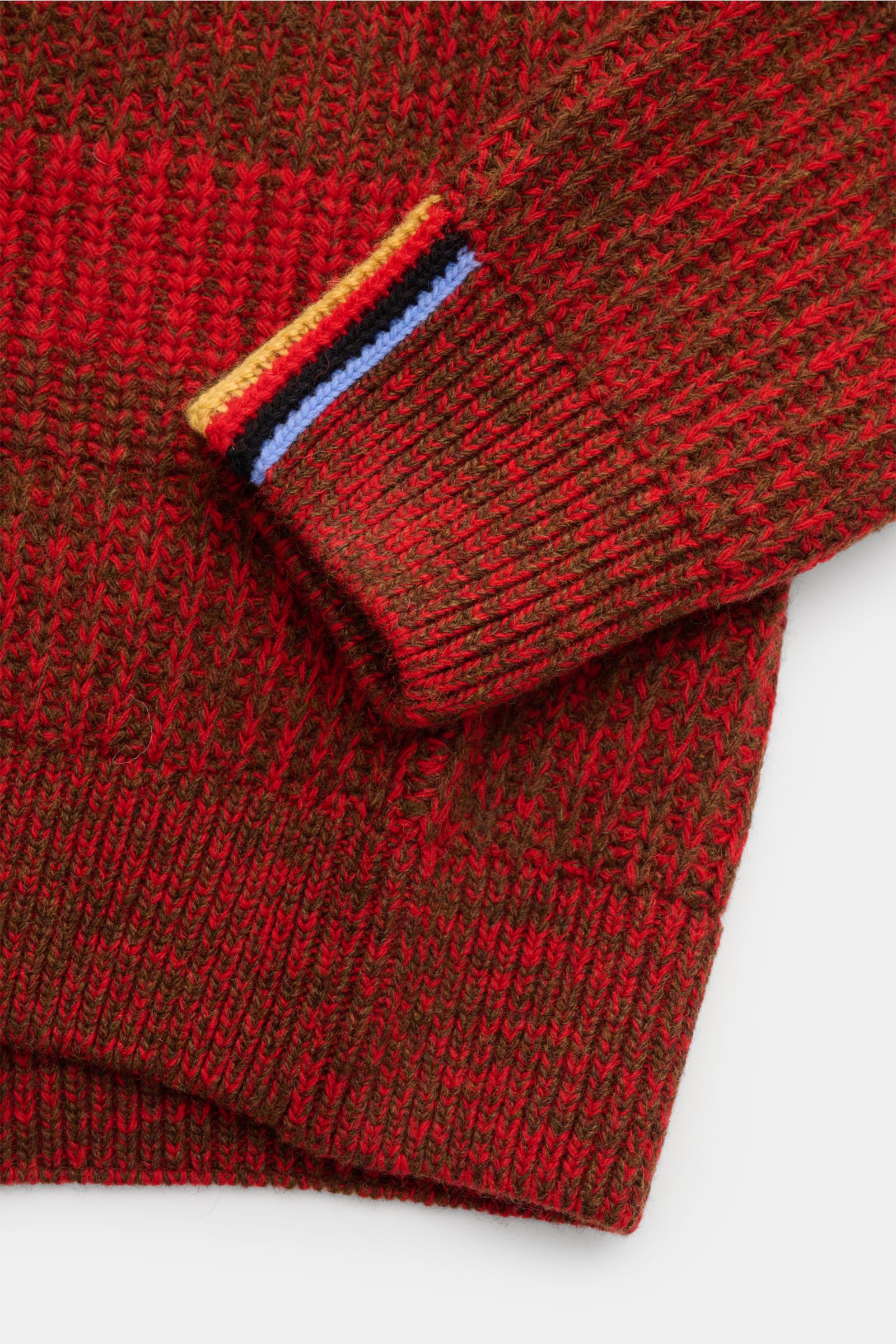 Close-up image of the Barbour Rundhalspullover 'Saddle' rot/khaki gestreift showing the textured red and khaki knit fabric and the sleeve cuff with Paul Smith stripes from an overhead angle. PAUL SMITH LOVES BARBOUR präsentiert im Rahmen einer exklusiv
