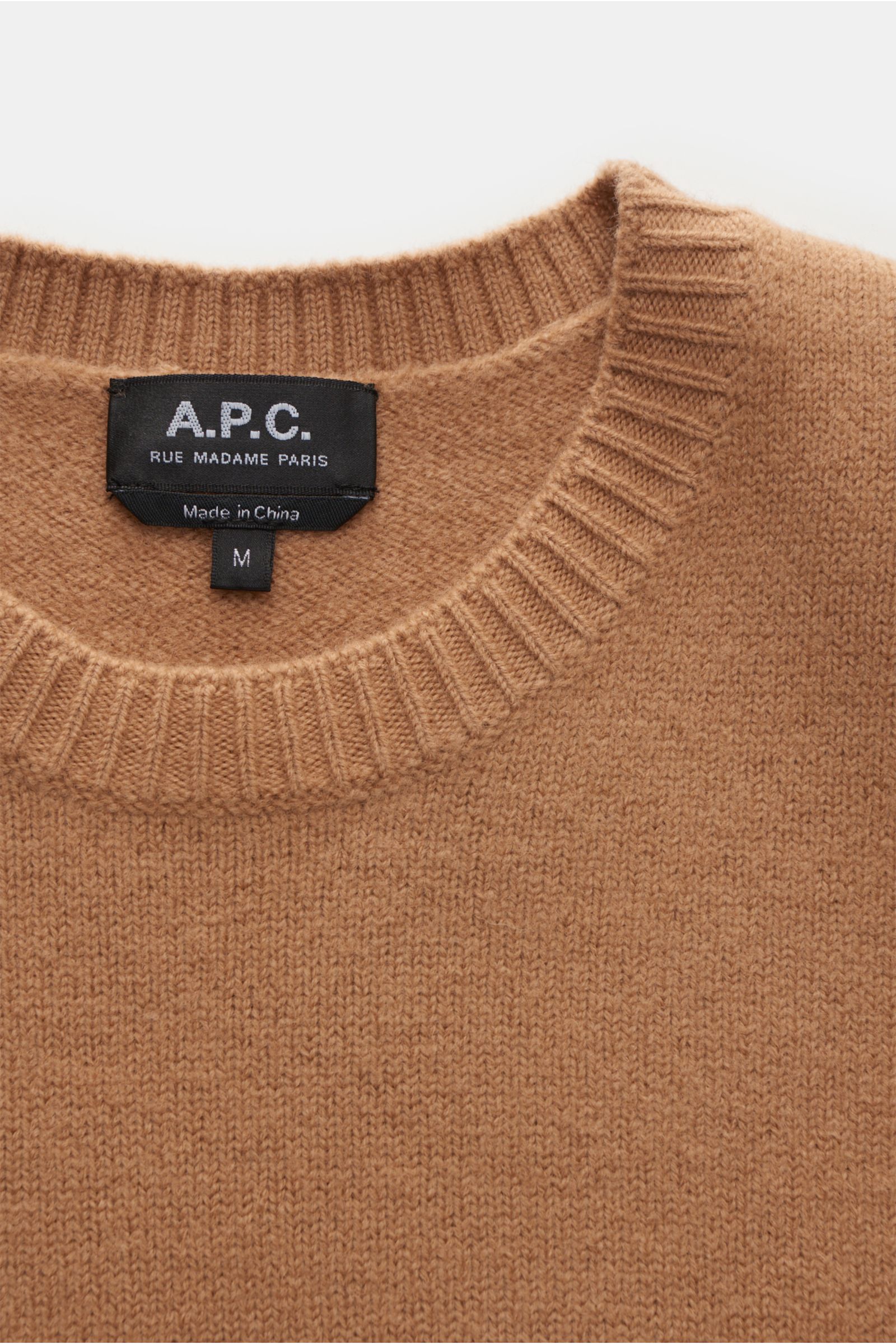 A.P.C. Rundhalspullover 'Edward' camel, Nahaufnahme von oben, reine Wolle, weicher Griff, mittelfeines Strickbild, Slim Fit, flexible Rippbündchen, dezentes Logo.