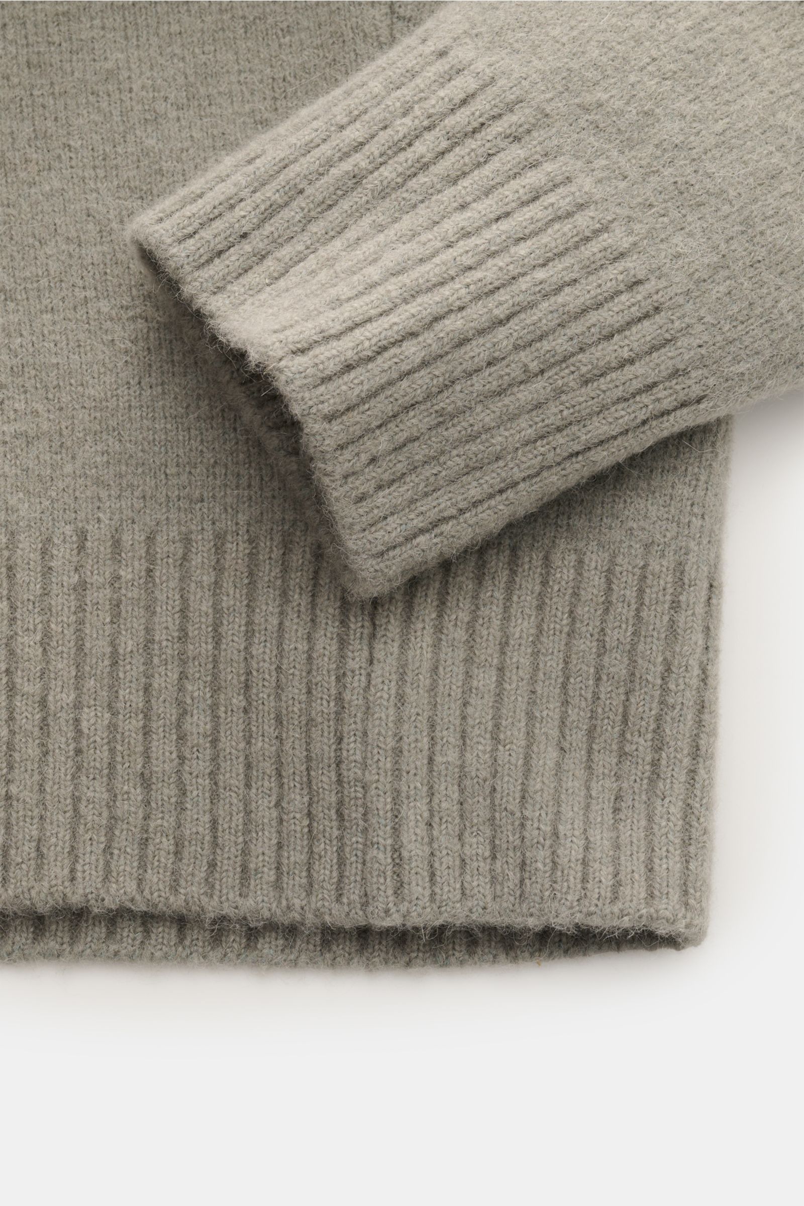 Close-up front view of the Ami Paris Rundhalspullover grau, showing the ribbed cuffs and hem in a soft, voluminous alpaca, wool, and microfiber knit, featuring a cozy oversized fit and round neckline with an integrated heart logo. Legerer Luxus für kalte 