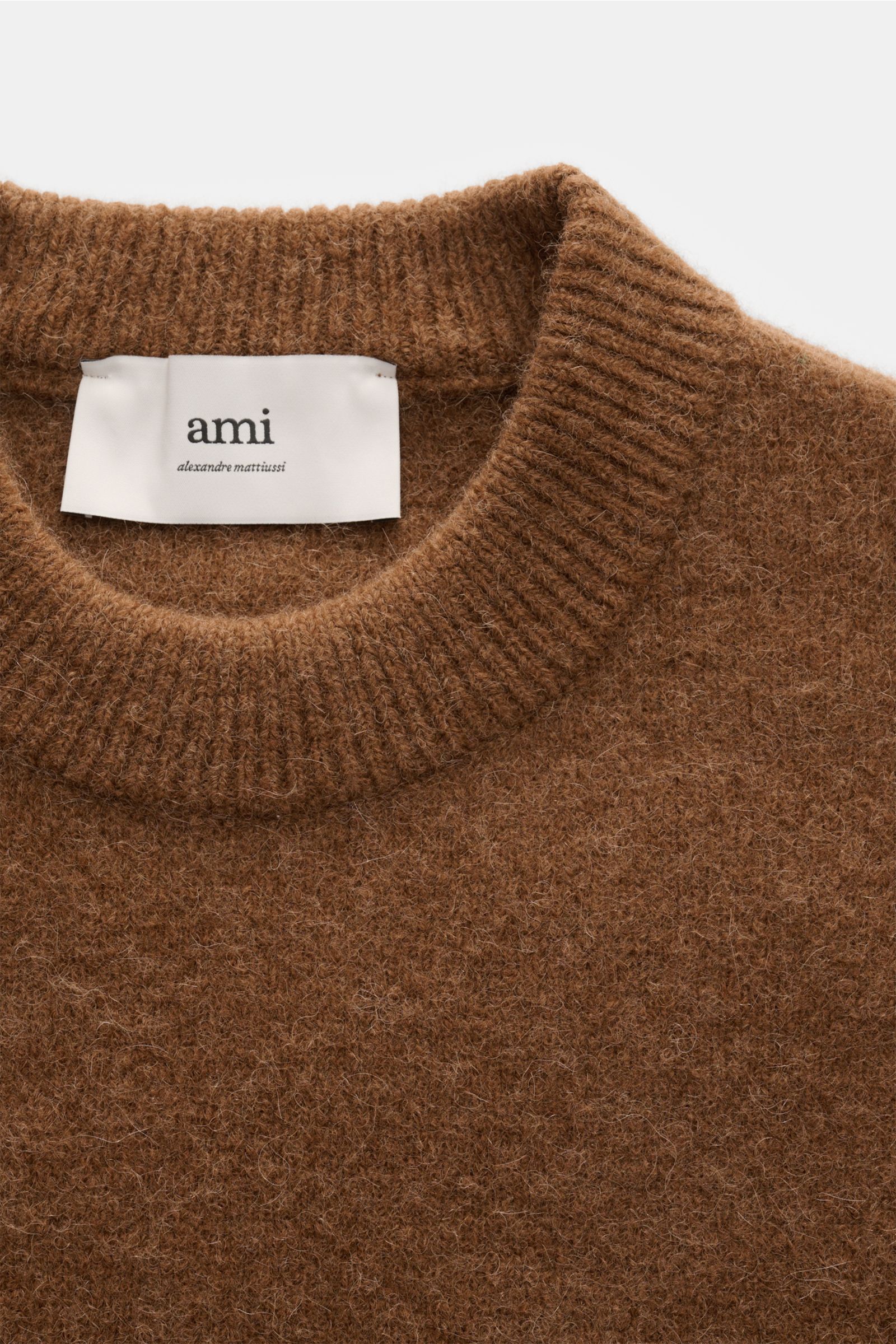 Nahaufnahme des Ami Paris Rundhalspullover hellbraun von oben, gestrickt aus elastischer Alpakawoll-Mischung mit weichem Griff.