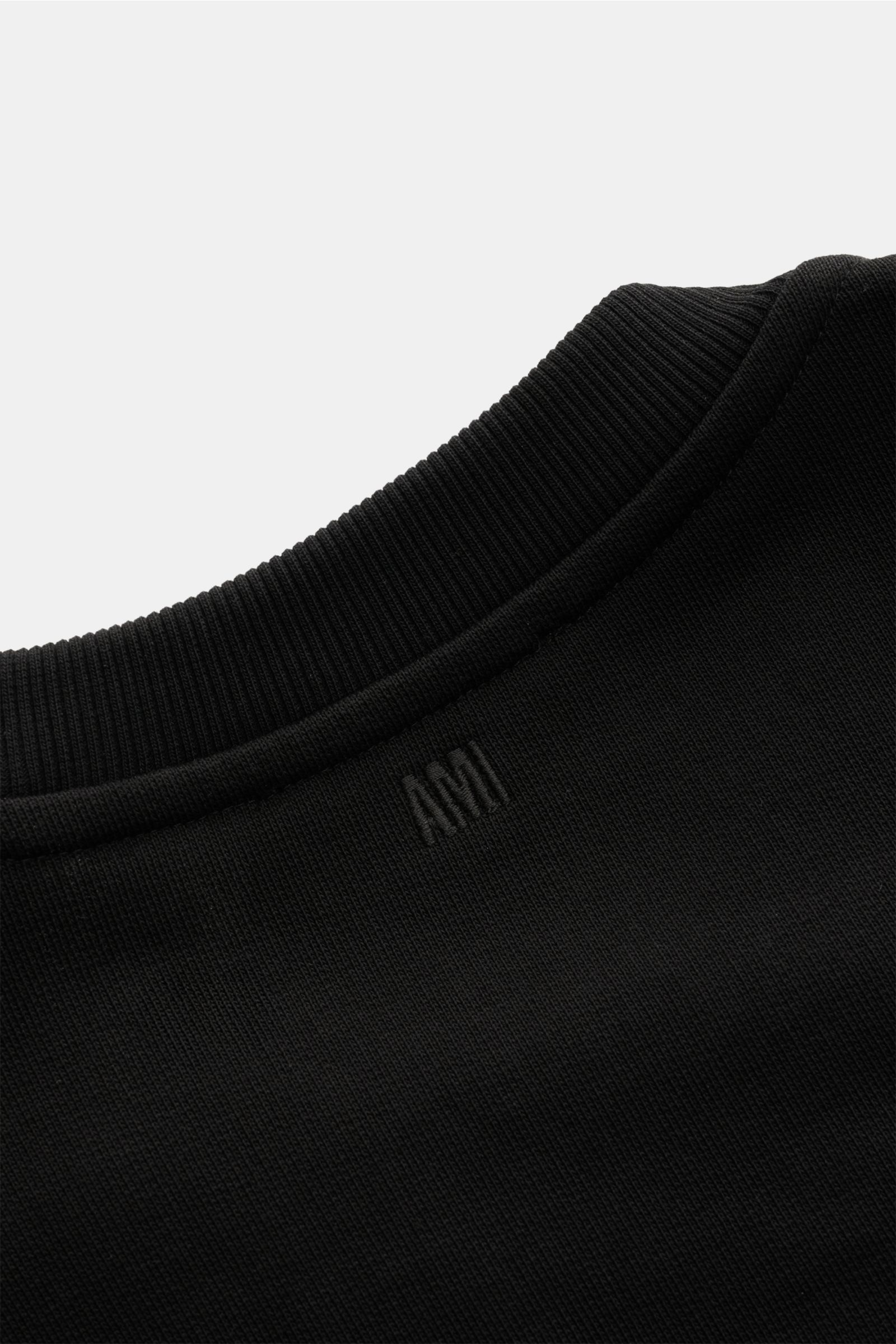 Close-up rear view of the Ami Paris Rundhals-Sweatshirt schwarz showing ribbed round neckline and subtle AMI stitching on black organic cotton fabric, made from sweat cotton with a slightly textured feel, unisex oversized fit, featuring comfortable ribbed