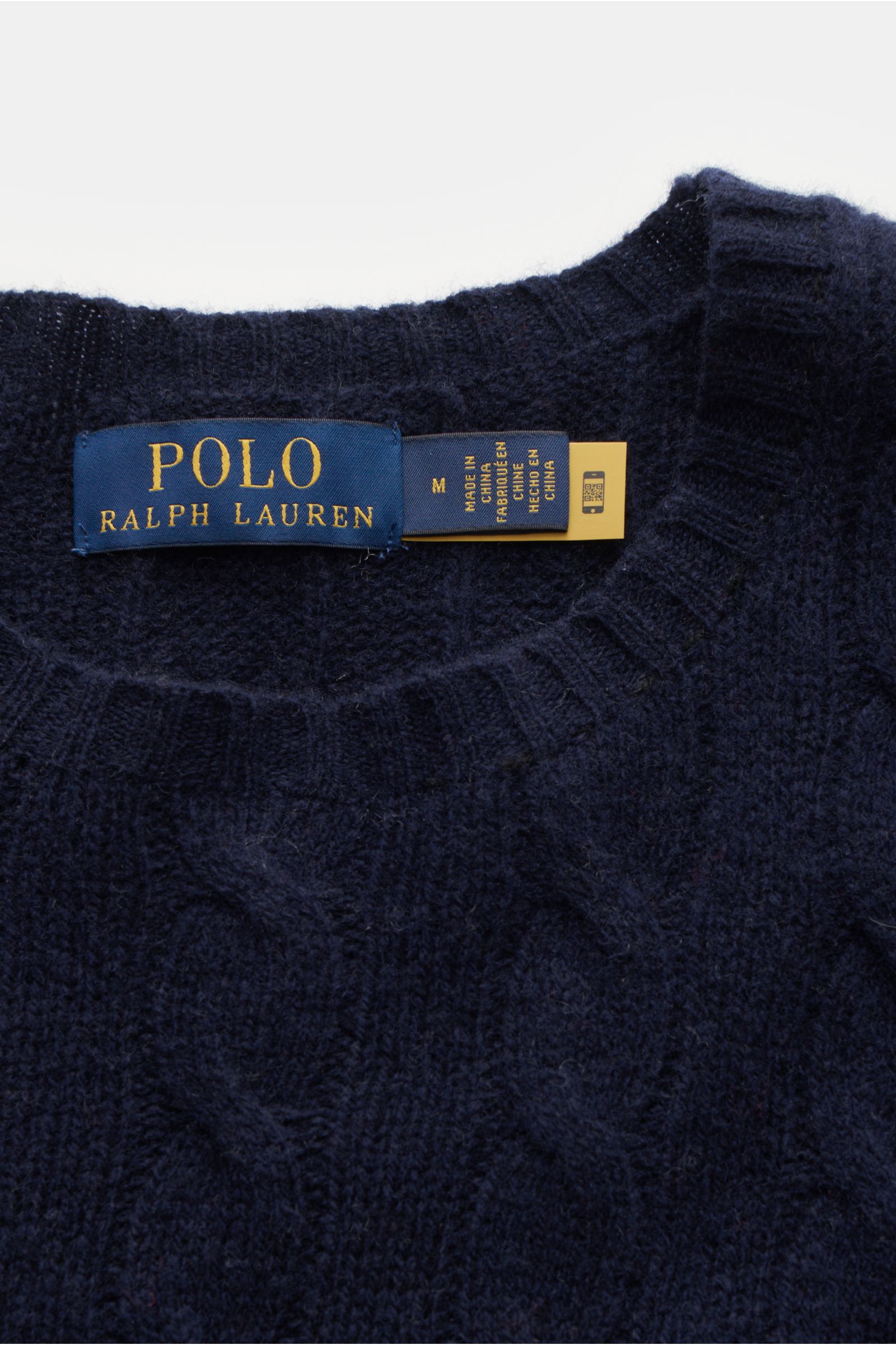 Close-up front view of the Polo Ralph Lauren Rundhalspullover dunkelblau showing the round neckline, structured cable knit pattern, and brand label. This classic sweater blends wool and cashmere for a soft feel, featuring a fine knit, slim fit, polo playe