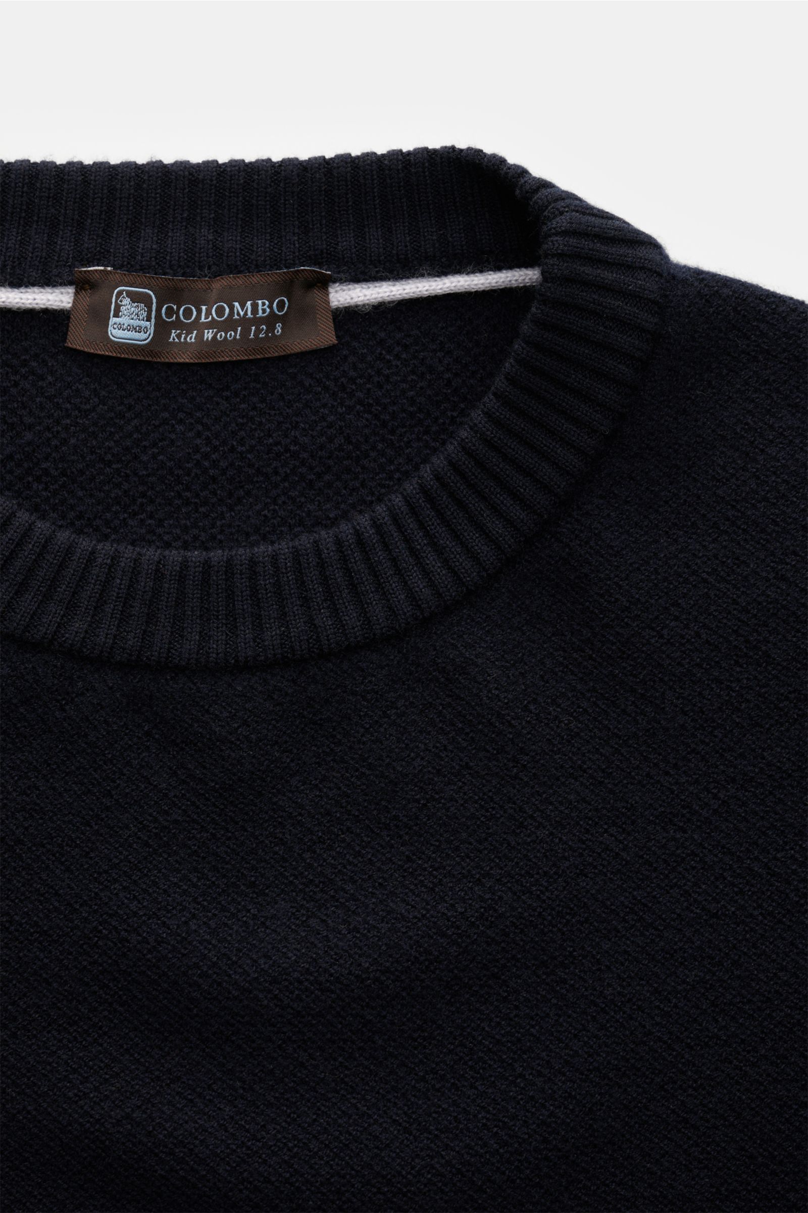 Close-up front view of the Colombo Rundhalspullover navy, a fine-structured, regular fit round neck sweater with flexible ribbed cuffs made of pure Kid Wool.

Description: Stilsicher durch die kalte Jahreszeit: Mit dem zeitlosen Rundhalspullover des it