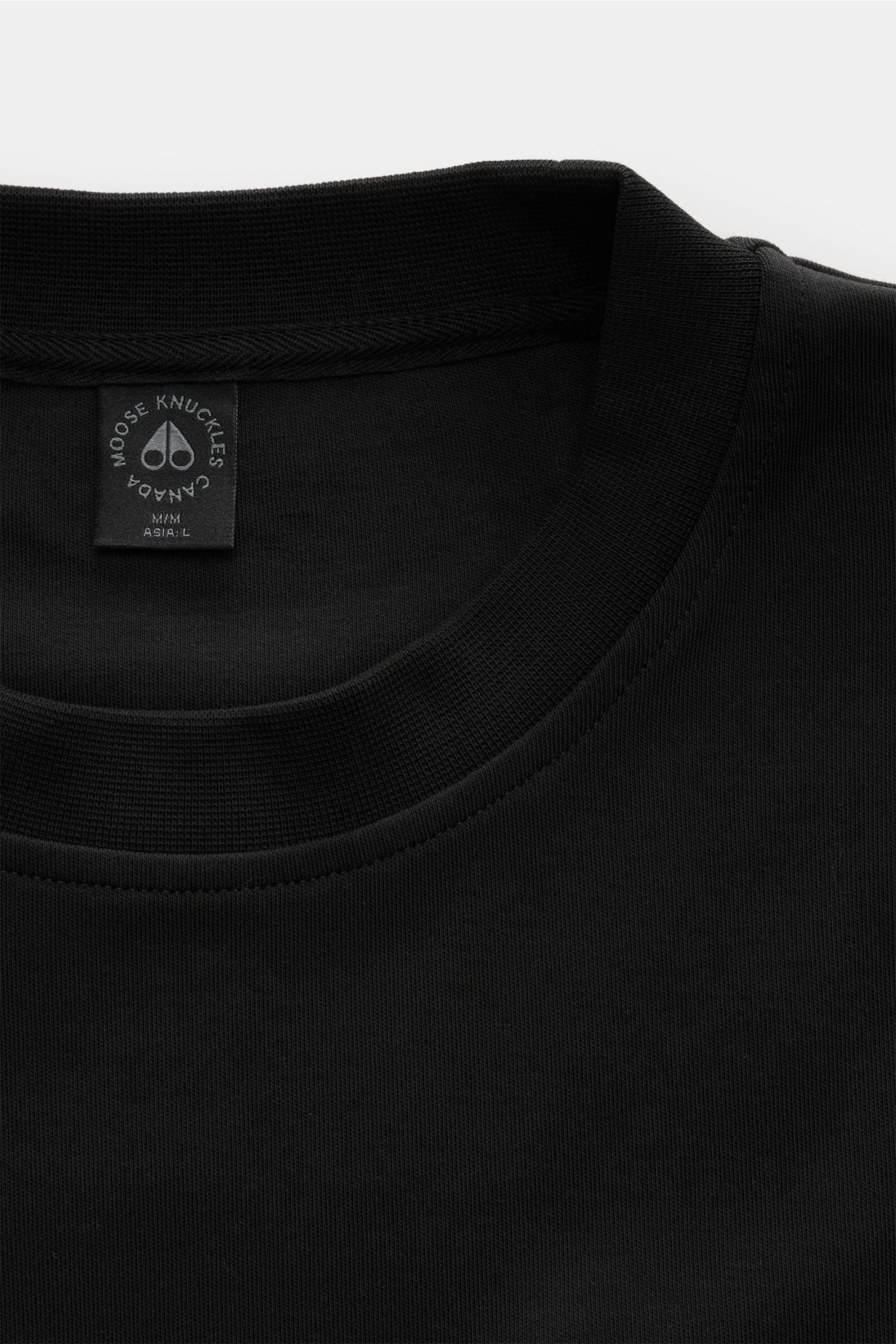 Close-up front view of Moose Knuckles Crew neck sweatshirt 'Dalon Crew' black, showing crew neck and fabric texture.

Refined sportswear: A practical zip pocket featuring the signature MOOSE KNUCKLES logo in metal stands out on the front of the crew ne