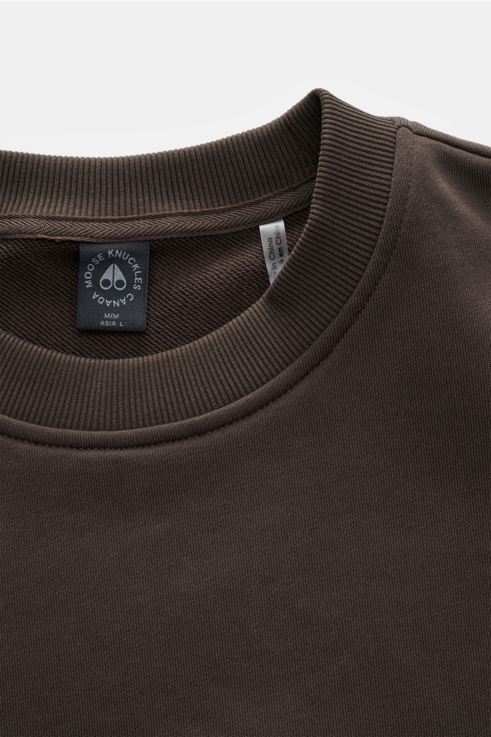 Moose Knuckles Sweatshirt 'Hartsfield Crew' graubraun shown from a top-front close-up of the ribbed round neckline and label. Veredelte Sportswear: Auf dem Oberarm des Sweatshirts 'Hartsfield Crew' aus reiner Baumwolle prangt ein Patch mit dem charakte