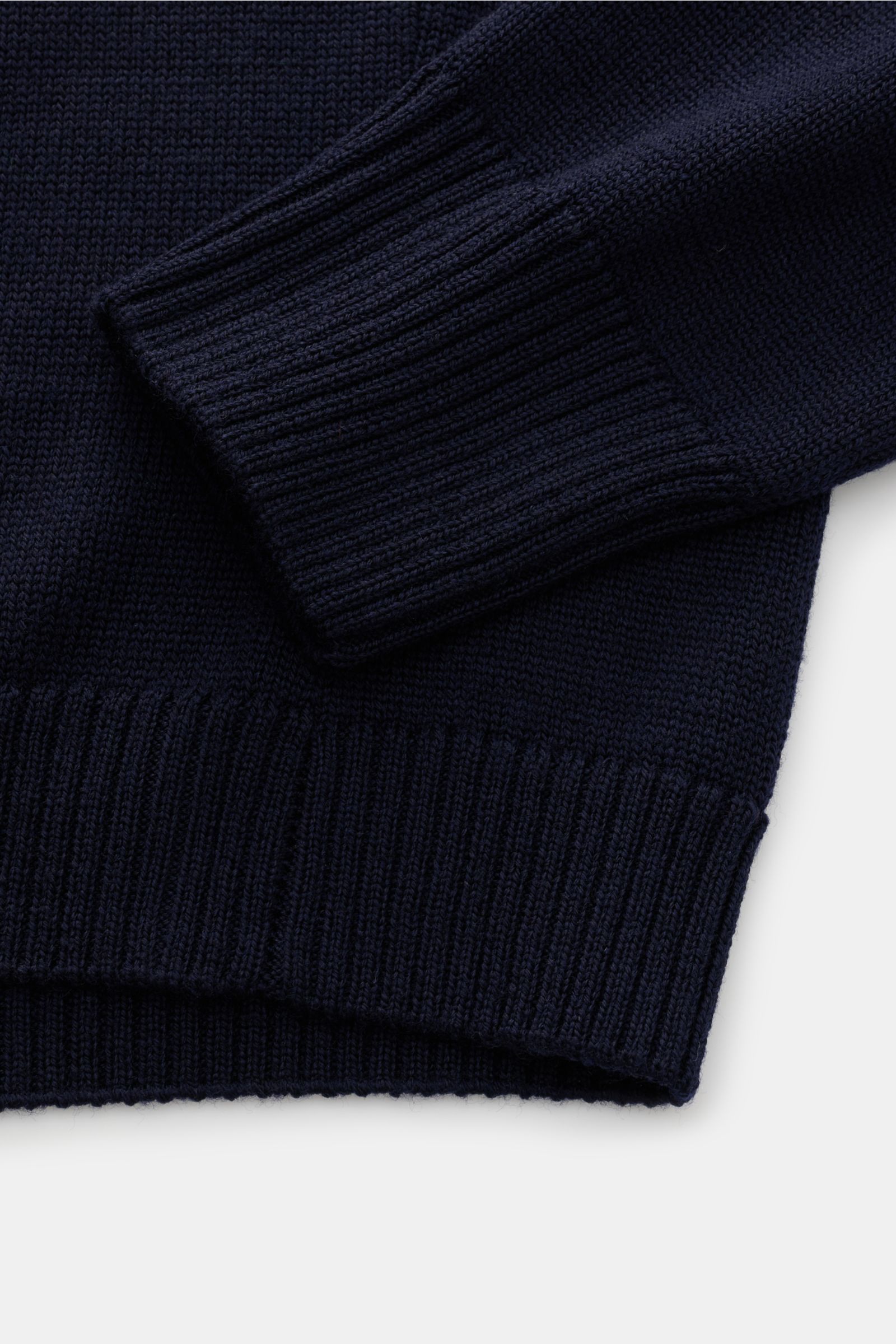 Nahaufnahme des B.F. Knitwear Merino Rundhalspullover navy mit weichem Griff, mittelgrobem Strickbild, Slim Fit, Rundhalsausschnitt und flexiblen Rippstrick-Bündchen aus reiner Merinowolle.