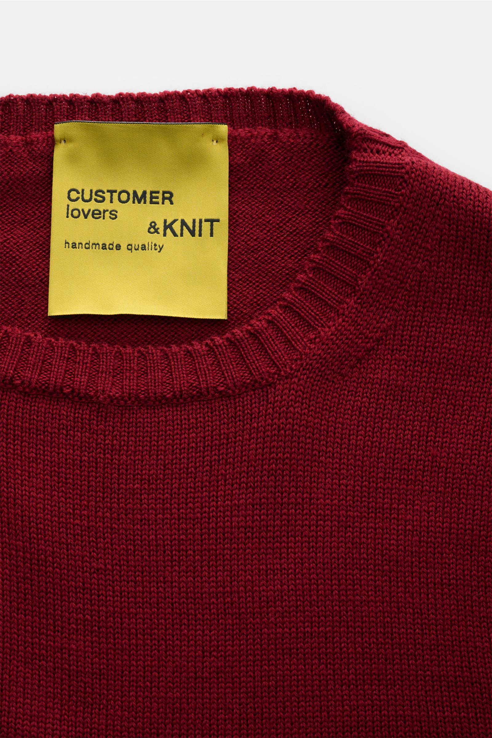 B.F. Knitwear Merino Rundhalspullover dunkelrot, Nahaufnahme von oben, reine Merinowolle, weicher Griff, mittelgrobes Strickbild, Slim Fit, Rundhalsausschnitt, flexible Rippstrick-Bündchen.