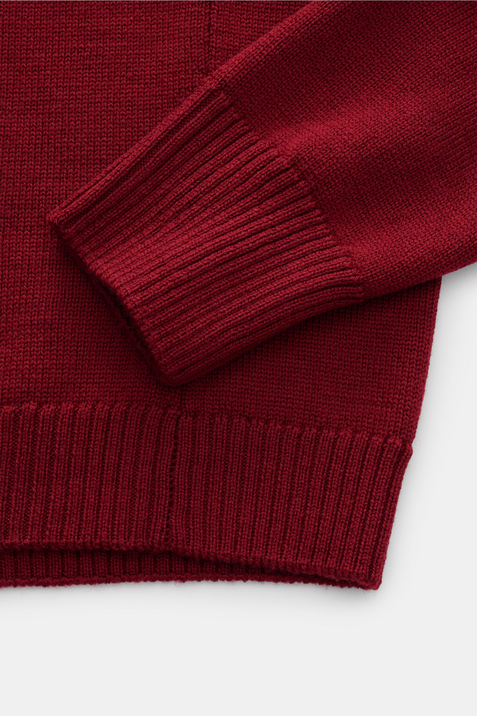 B.F. Knitwear Merino Rundhalspullover dunkelrot, Nahaufnahme von Ärmel und Saum, reine Merinowolle, weicher Griff, mittelgrobes Strickbild, Slim Fit, Rundhalsausschnitt, flexible Rippstrick-Bündchen.