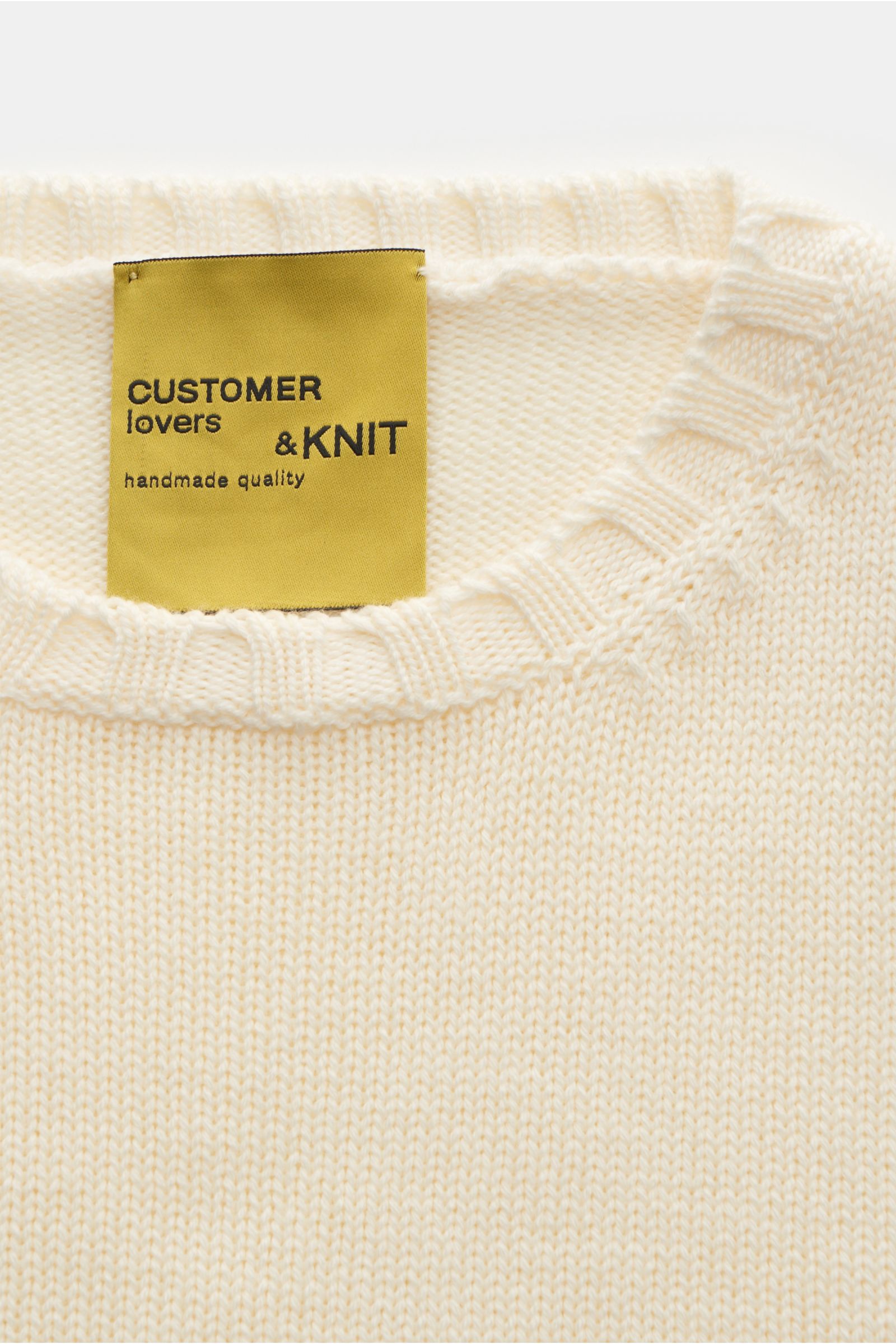 Close-up front view of the B.F. Knitwear Merino Rundhalspullover creme, showing reine Merinowolle, weicher Griff, mittelgrobes Strickbild, Slim Fit, Rundhalsausschnitt, and breite Rippstrick-Bündchen.