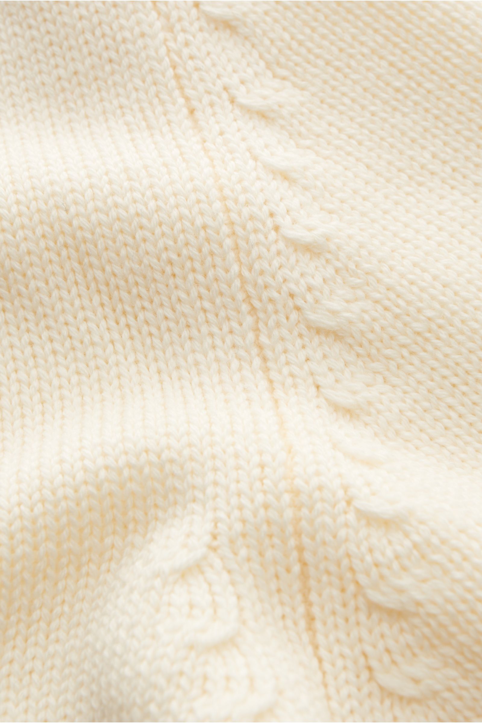 Close-up front view of B.F. Knitwear Merino Rundhalspullover creme showing pure merino wool, soft touch, medium knit texture, slim fit, round neckline, and wide ribbed cuffs.