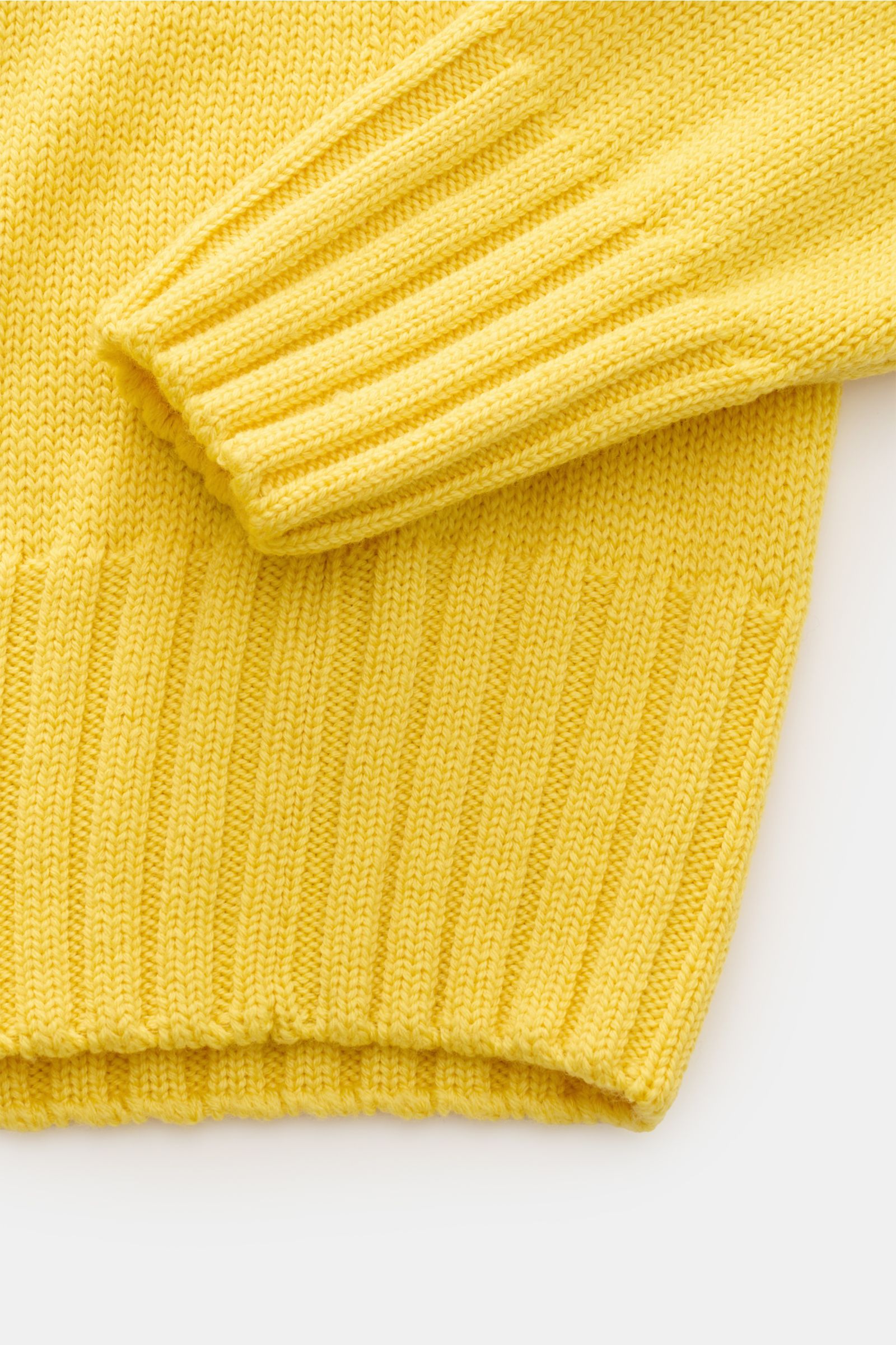 Nahaufnahme des gelben B.F. Knitwear Merino Rundhalspullovers, Slim Fit aus reiner Merinowolle mit weichem Griff, mittelgrobem Strickbild, Rundhalsausschnitt und breiten Rippstrick-Bündchen.