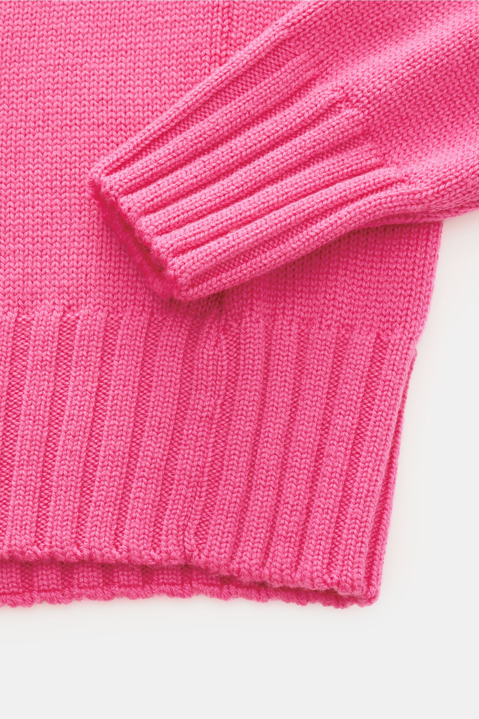 B.F. Knitwear Merino Rundhalspullover magenta aus reine Merinowolle, weicher Griff, Slim Fit, Rundhalsausschnitt, mittleres Strickbild, breite Rippstrick-Bündchen, Detailaufnahme von unten.