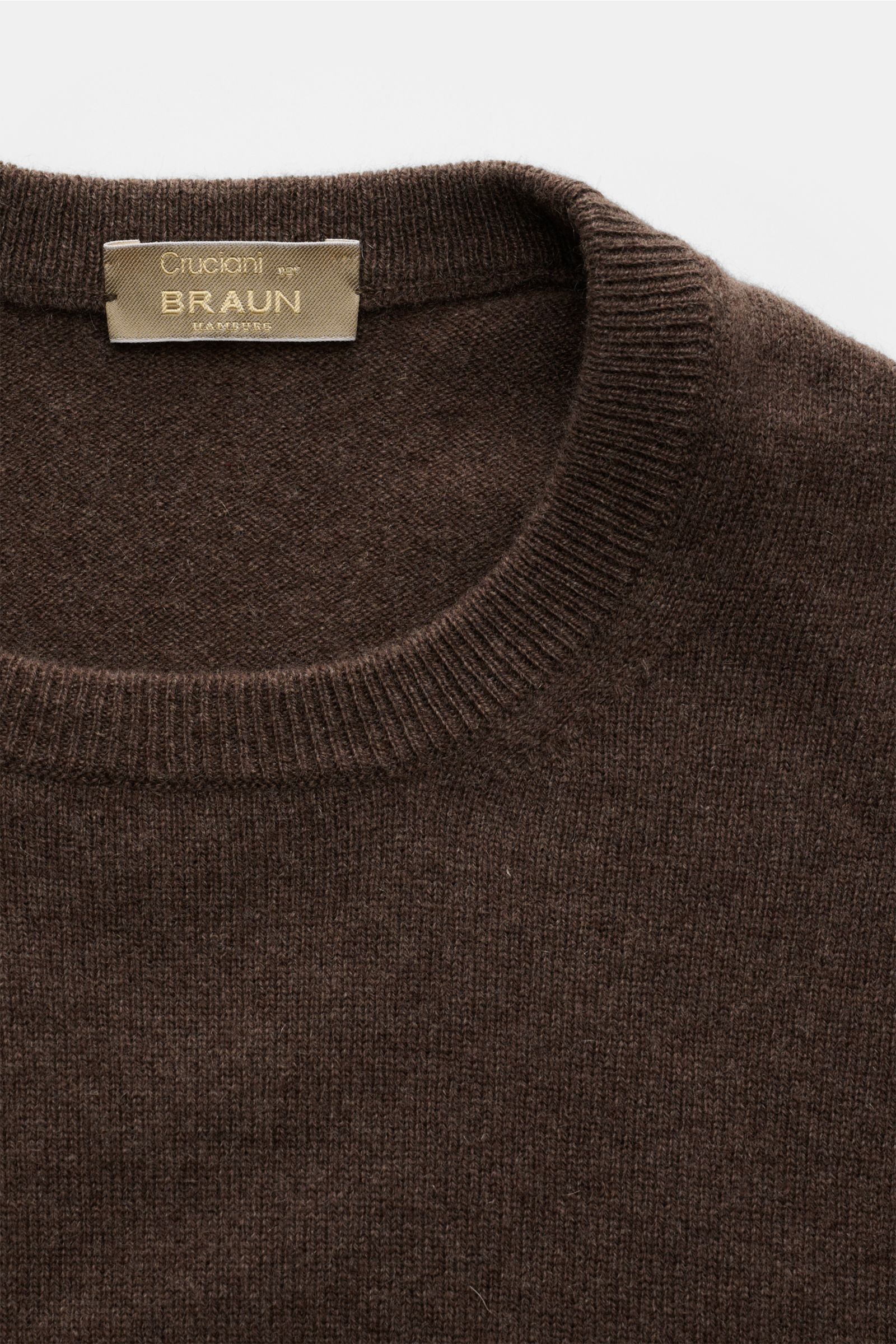 Close-up front view of a brown Cruciani Cashmere Rundhalspullover braun with a round neckline and fine knit texture. Durch die Verwendung feinster, geschmeidiger Cashmere-Garne entsteht bei CRUCIANI ein klassischer Rundhalspullover, der Wärme spendet u