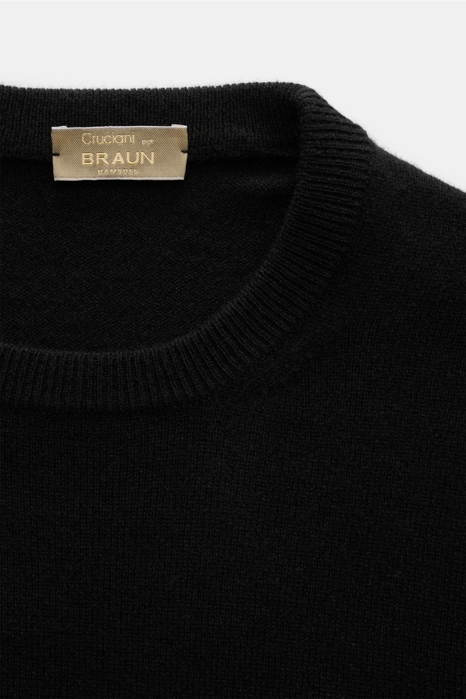 Cruciani Cashmere Rundhalspullover schwarz, Nahaufnahme von oben, feines Strickbild, Slim Fit, Rundhalsausschnitt, elastische Bündchen, reiner Cashmere, geschmeidig, vielseitig.