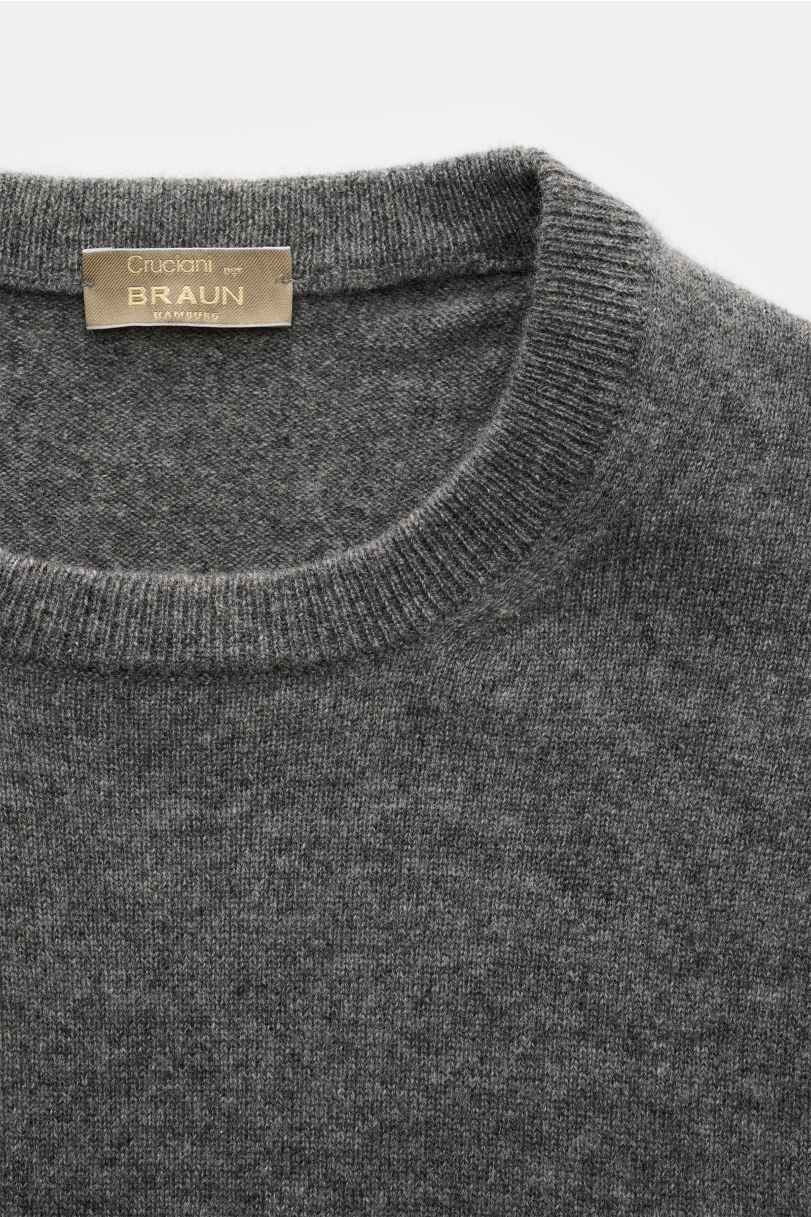 Close-up front-top view of Cruciani Cashmere Rundhalspullover dunkelgrau meliert, showing round neckline and fine knit texture.

Description: Durch die Verwendung feinster, geschmeidiger Cashmere-Garne entsteht bei CRUCIANI ein klassischer Rundhalspull