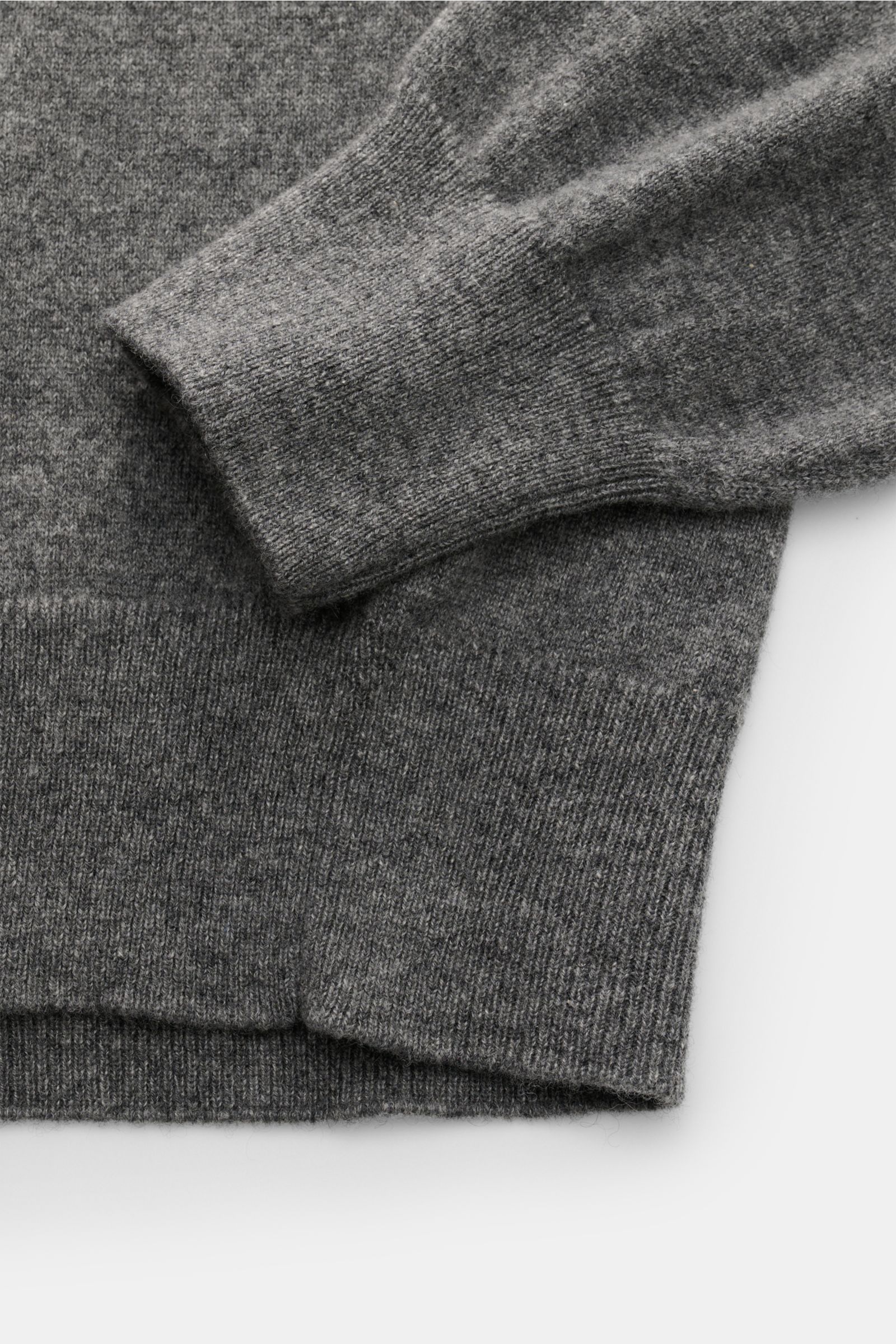 Close-up top-down view of Cruciani Cashmere Rundhalspullover dunkelgrau meliert showing fine knit, elastic ribbed cuffs, and slim fit design.

Description:  
Durch die Verwendung feinster, geschmeidiger Cashmere-Garne entsteht bei CRUCIANI ein klassisc