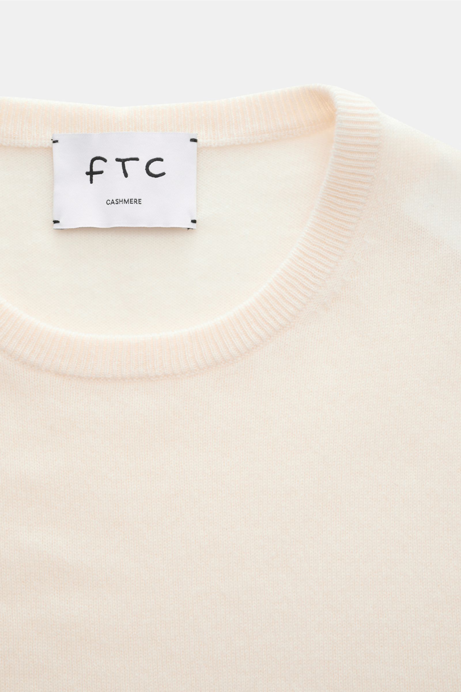 FTC Cashmere Rundhalspullover creme aus reiner, ultraweicher Cashmere-Qualität mit feinem Strickbild, Slim Fit, Rundhalsausschnitt, Rippbündchen, Nahaufnahme von oben.