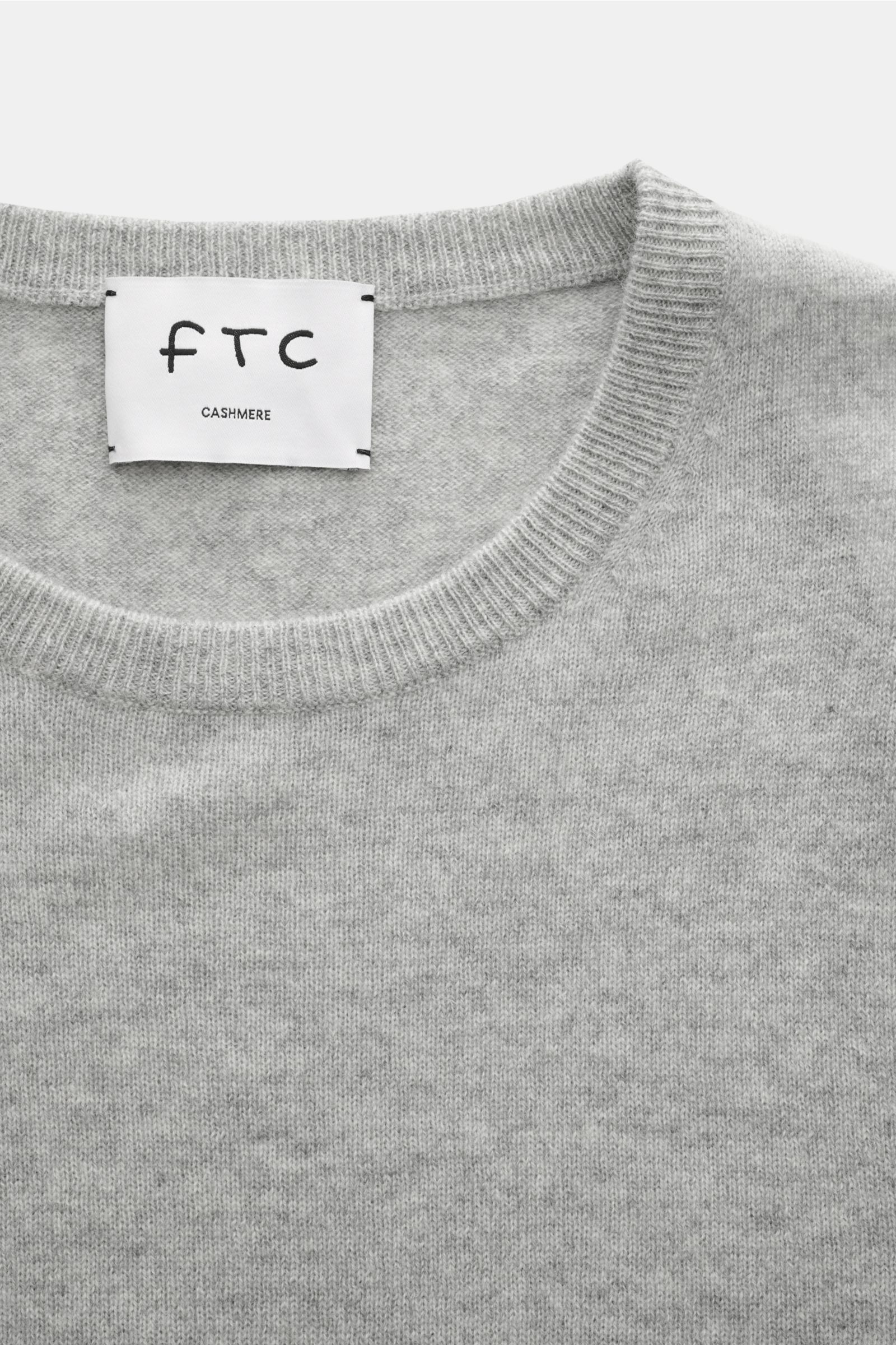 Nahaufnahme des FTC Cashmere Rundhalspullover grau meliert von oben, zeigt feines Strickbild, Slim Fit, Rundhalsausschnitt und weiche Rippbündchen.