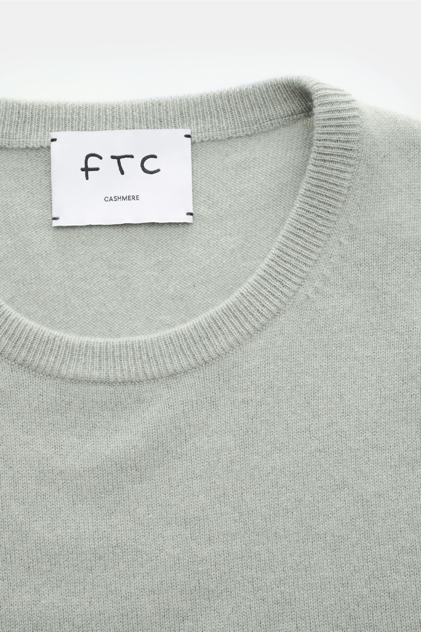 Close-up top-down view of FTC Cashmere crew neck jumper grey-green showing fine knit fabric and ribbed crew neck collar.

The feel of ultra soft cashmere fabric makes this timeless crew neck jumper by sustainable knitwear label FTC CASHMERE a knitted f