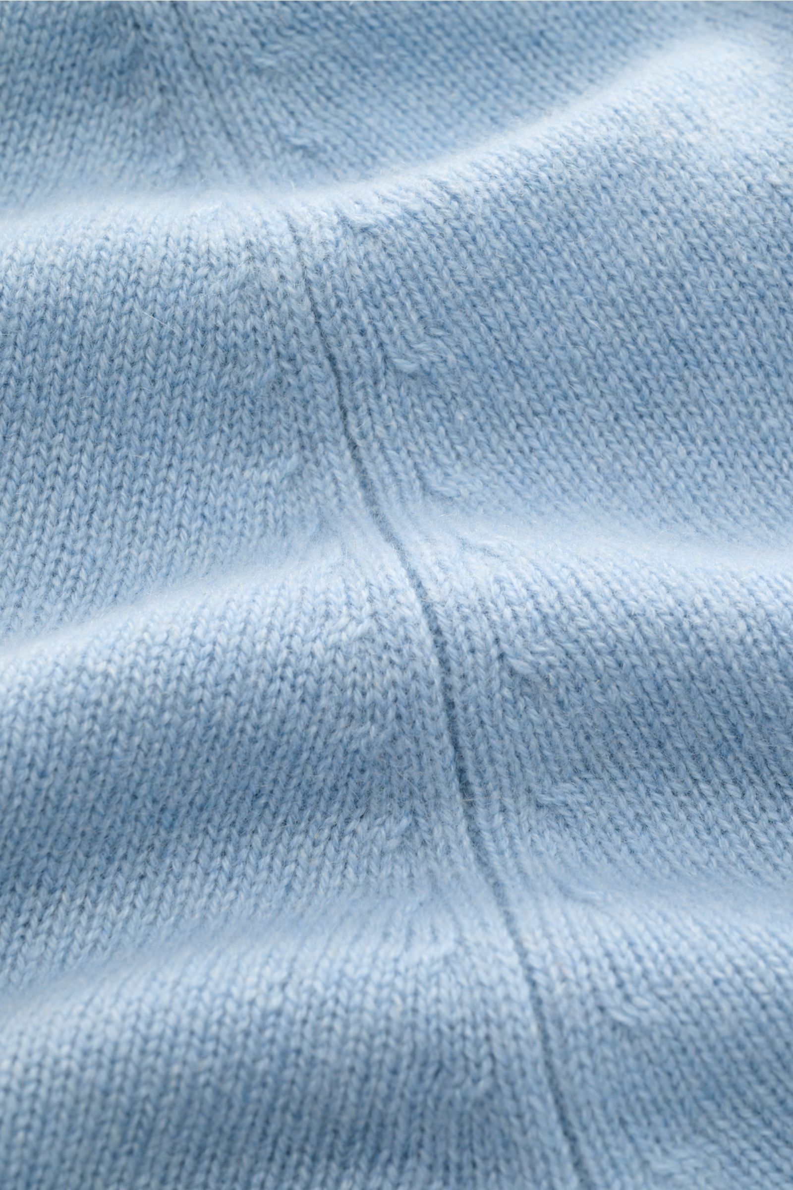 Close-up front detail of the FTC Cashmere crew neck jumper light blue, showing medium-fine knit, raglan sleeves, and ribbed bands. Pure fair trade cashmere, OEKO-TEX® certified, very soft feel, slim fit, crew neck.