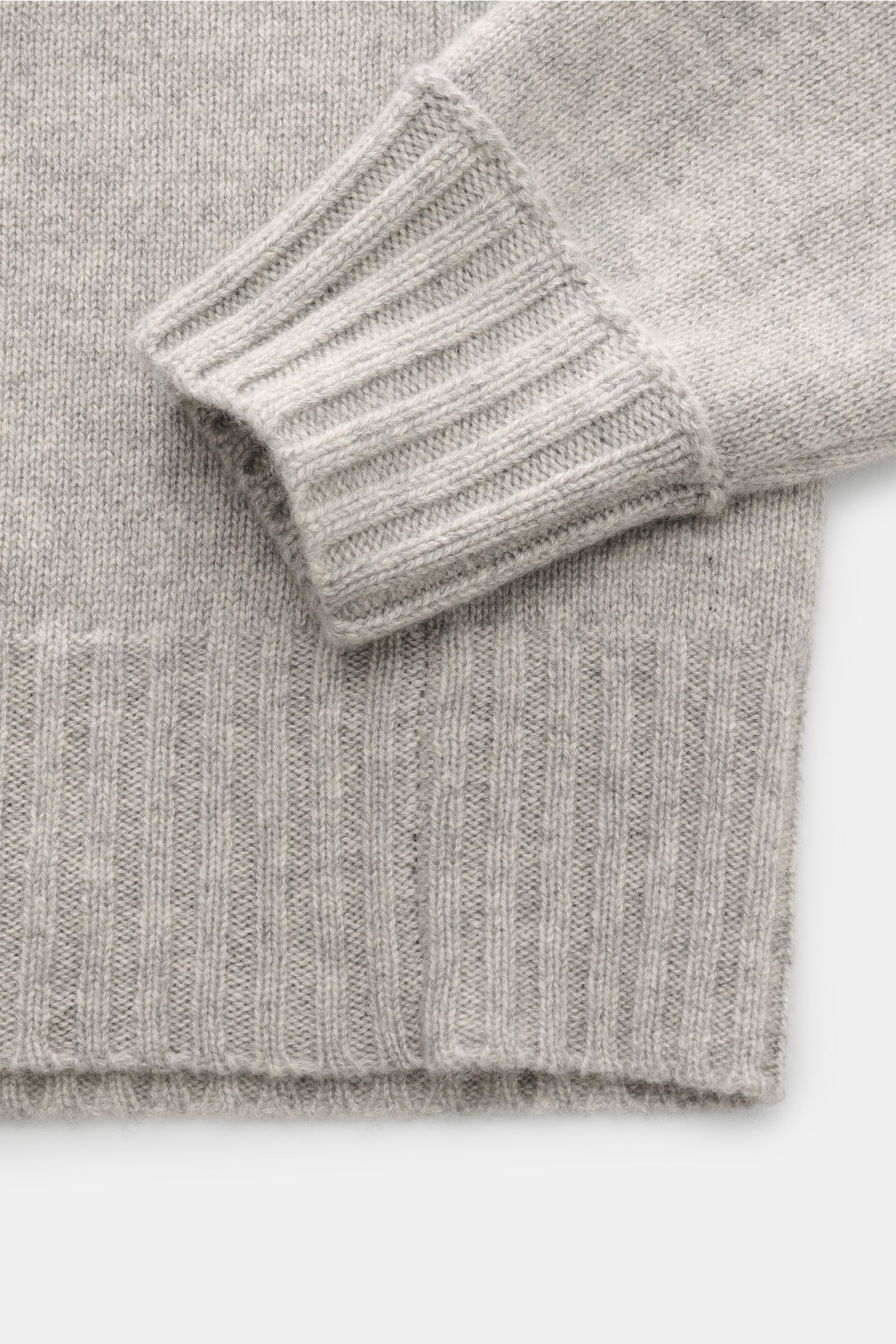 Close-up image of the FTC Cashmere crew neck jumper grey mottled, showing the sleeve cuff and hem from a top-down perspective, featuring pure fair trade cashmere, OEKO-TEX® certified, very soft feel, medium-fine knit, slim fit, crew neck, raglan sleeves, 