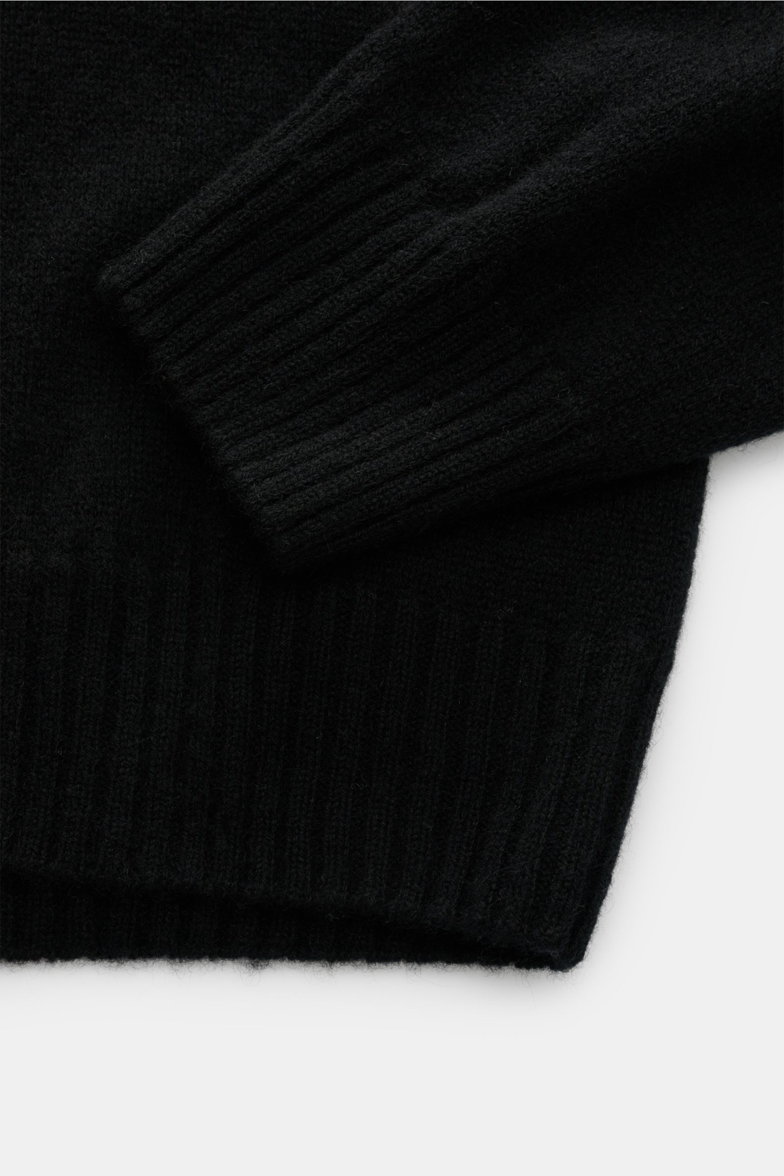 Schwarz fotografierter Ausschnitt des 04651/ A trip in a bag Cashmere Rundhalspullover 'Extreme Cashmere Crew' mit feinem Strick und Rippbündchen.