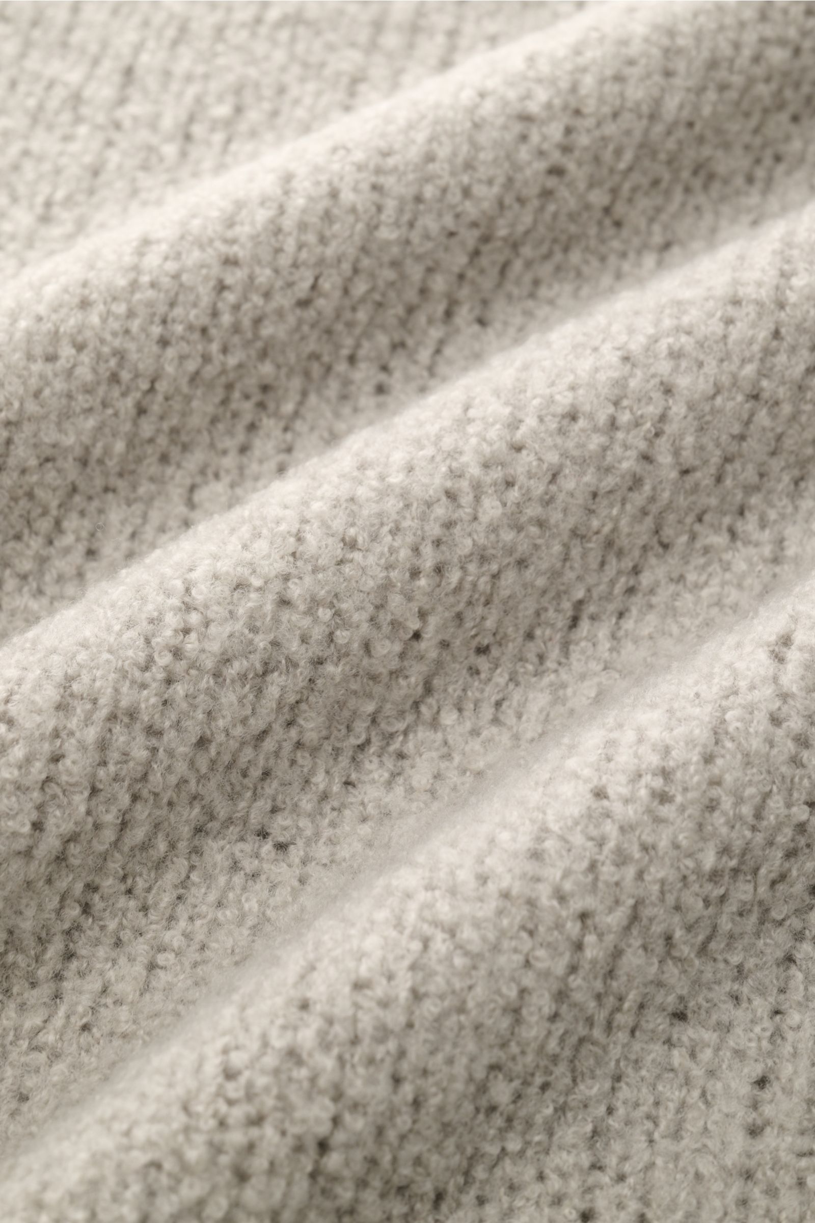 Detailaufnahme der Bouclé-Struktur des 04651/ A trip in a bag Rundhalspullover 'Grainy Crew' sand, weicher Woll-Mix, nah fotografiert.