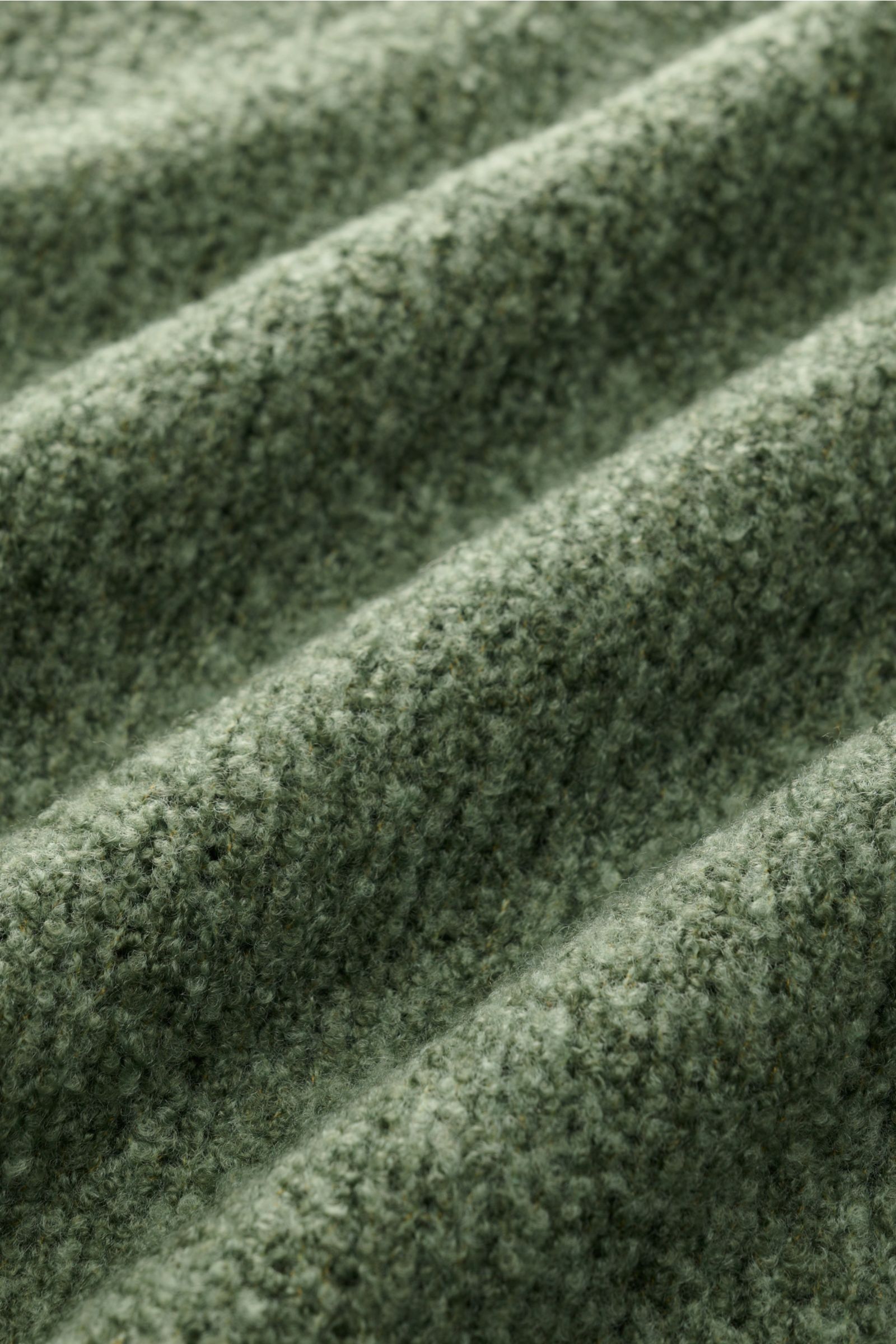 Nahaufnahme der graugrünen Bouclé-Struktur des 04651/ A trip in a bag Rundhalspullover 'Grainy Crew', weicher Woll-Microfaser-Mix.