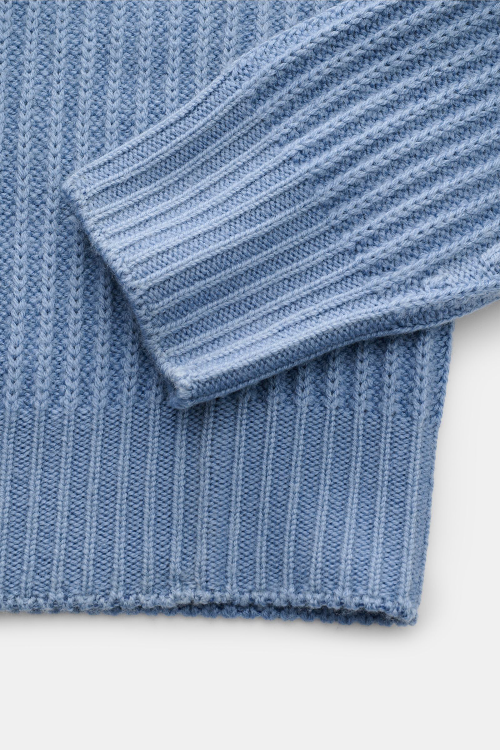 Nahaufnahme des 04651/ A trip in a bag Mock Neck Pullover 'Foggy Mock' rauchblau, zeigt weiches, grobes Rippstrickmuster aus reiner Wolle, Slim Fit, Stehkragen und komfortable Rippbündchen, fotografiert von oben.