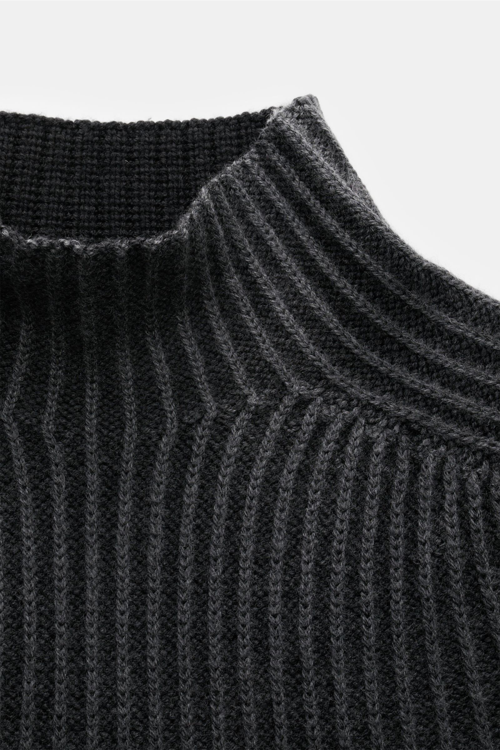 Nahaufnahme des schwarzen 04651/ A trip in a bag Mock Neck Pullover 'Foggy Mock' mit Stehkragen, grobem Rippstrick und weichem Griff aus reiner Wolle, fotografiert von oben.