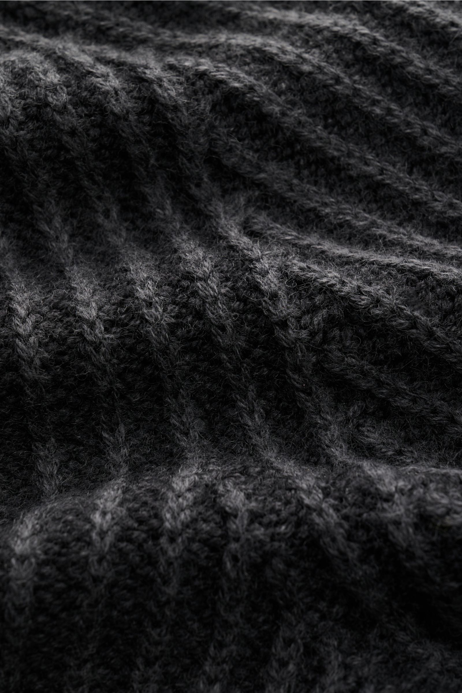 Nahaufnahme des grob gerippten Strickmusters des schwarzen 04651/ A trip in a bag Mock Neck Pullover 'Foggy Mock' aus reiner Wolle.