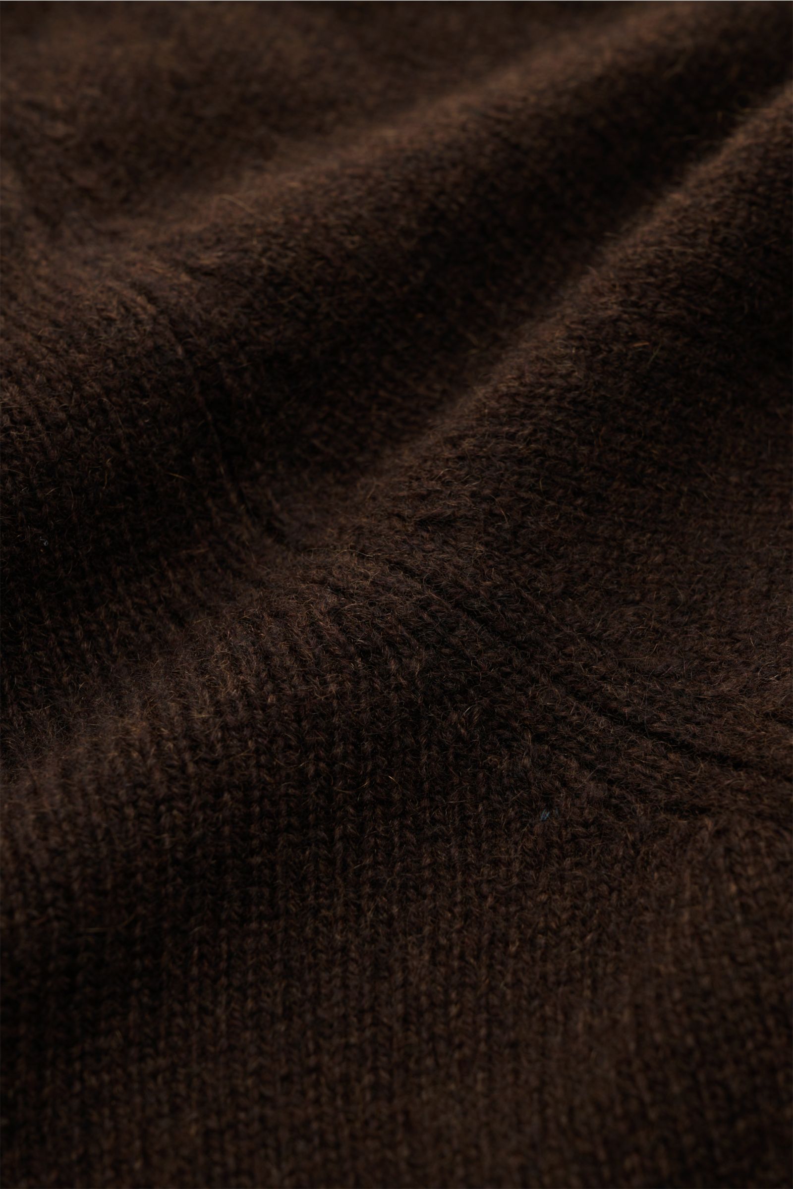 Nahaufnahme des braunen Malo Cashmere Rundhalspullovers aus reiner Cashmere-Faser, mittelfeines Strickbild, Slim Fit, Rundhalsausschnitt, sehr weicher Griff, komfortable Rippbündchen, textile Detailansicht.