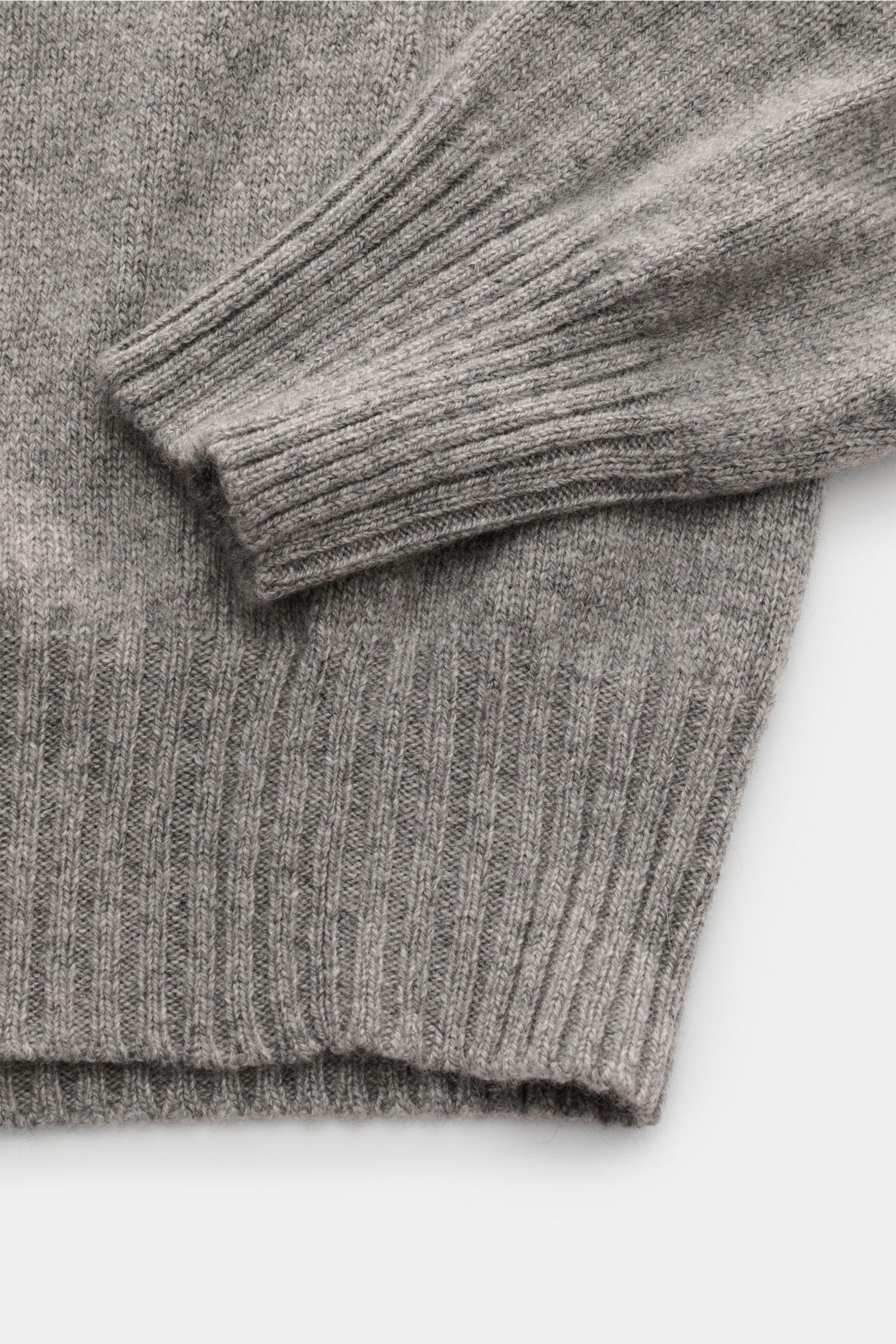 Nahaufnahme des grau melierten Malo Cashmere Rundhalspullovers mit reiner Cashmere, sehr weichem Griff, mittelfeinem Strickbild, Slim Fit, Rundhalsausschnitt und komfortablen Rippbündchen, fotografiert von oben.