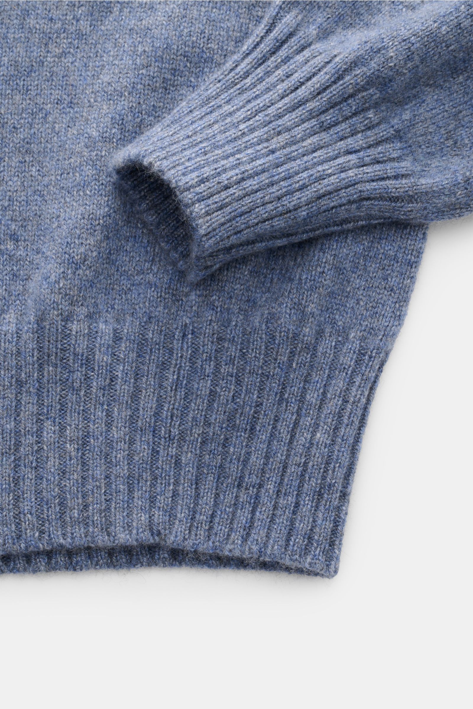 Nahaufnahme des Malo Cashmere Rundhalspullover rauchblau meliert mit mittelfeinem Strickbild, Slim Fit, Rundhalsausschnitt, reiner Cashmere, sehr weichem Griff und komfortablen Rippbündchen, fotografiert von oben.