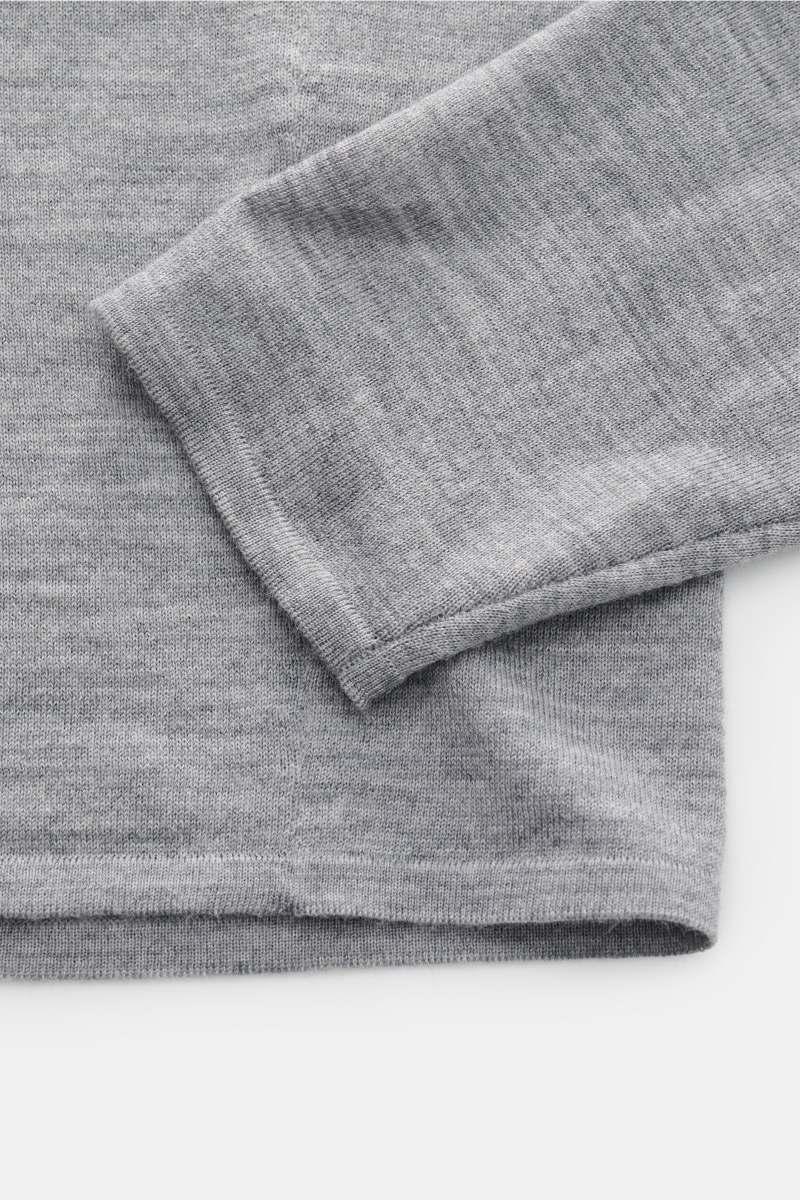 Nahaufnahme des Kiefermann Merino Feinstrick-Pullover grau meliert am Ärmel und Saum, reine Merinowolle, superweicher Griff, sehr feines Strickbild, Slim Fit, hoher Rundhalsausschnitt, elastische Ärmelabschlüsse.