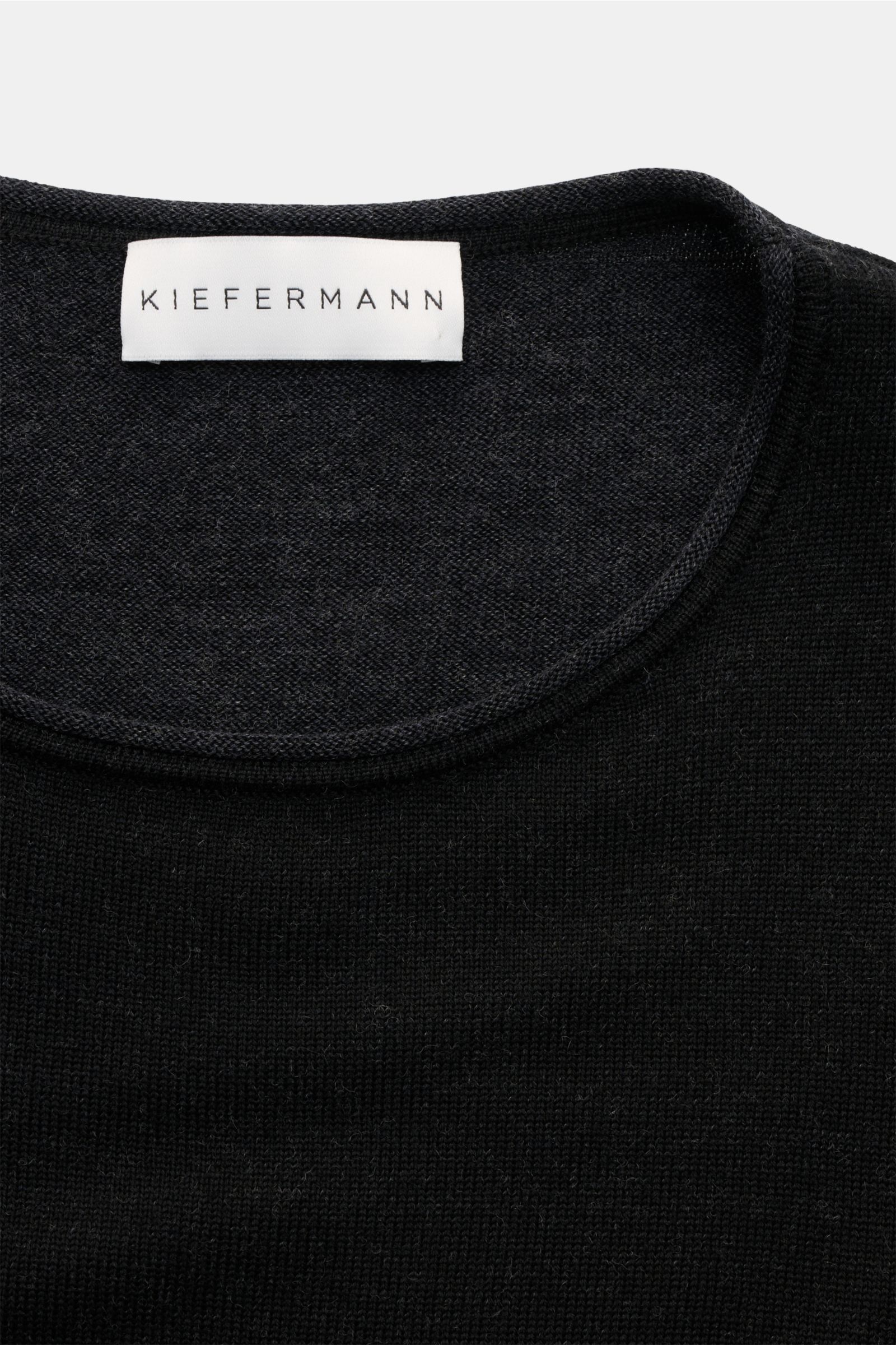Kiefermann Merino Rundhalspullover 'Lutzs' schwarz meliert, Slim Fit, weiche Merinowolle, Rundhalsausschnitt, kontrastfarbige Details, Nahaufnahme von oben.