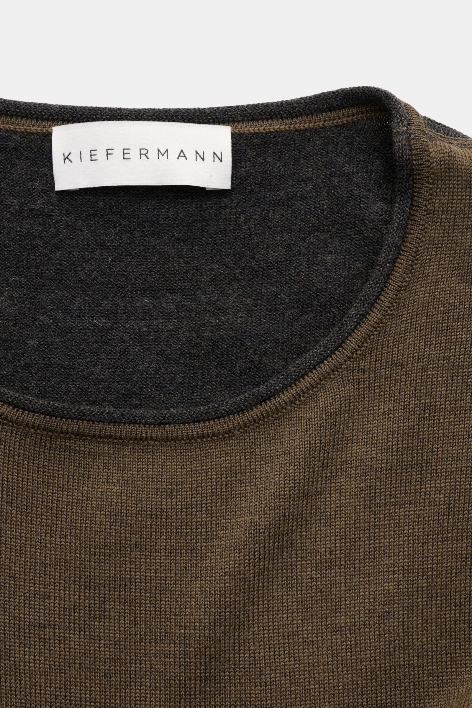 Close-up front view of Kiefermann Merino Rundhalspullover 'Lutzs' khaki meliert showing round neckline with rolled edge and fine knit texture.

Update für ein Essential: Der Rundhalspullover von KIEFERMANN aus weicher Merinowolle besticht durch zweifar