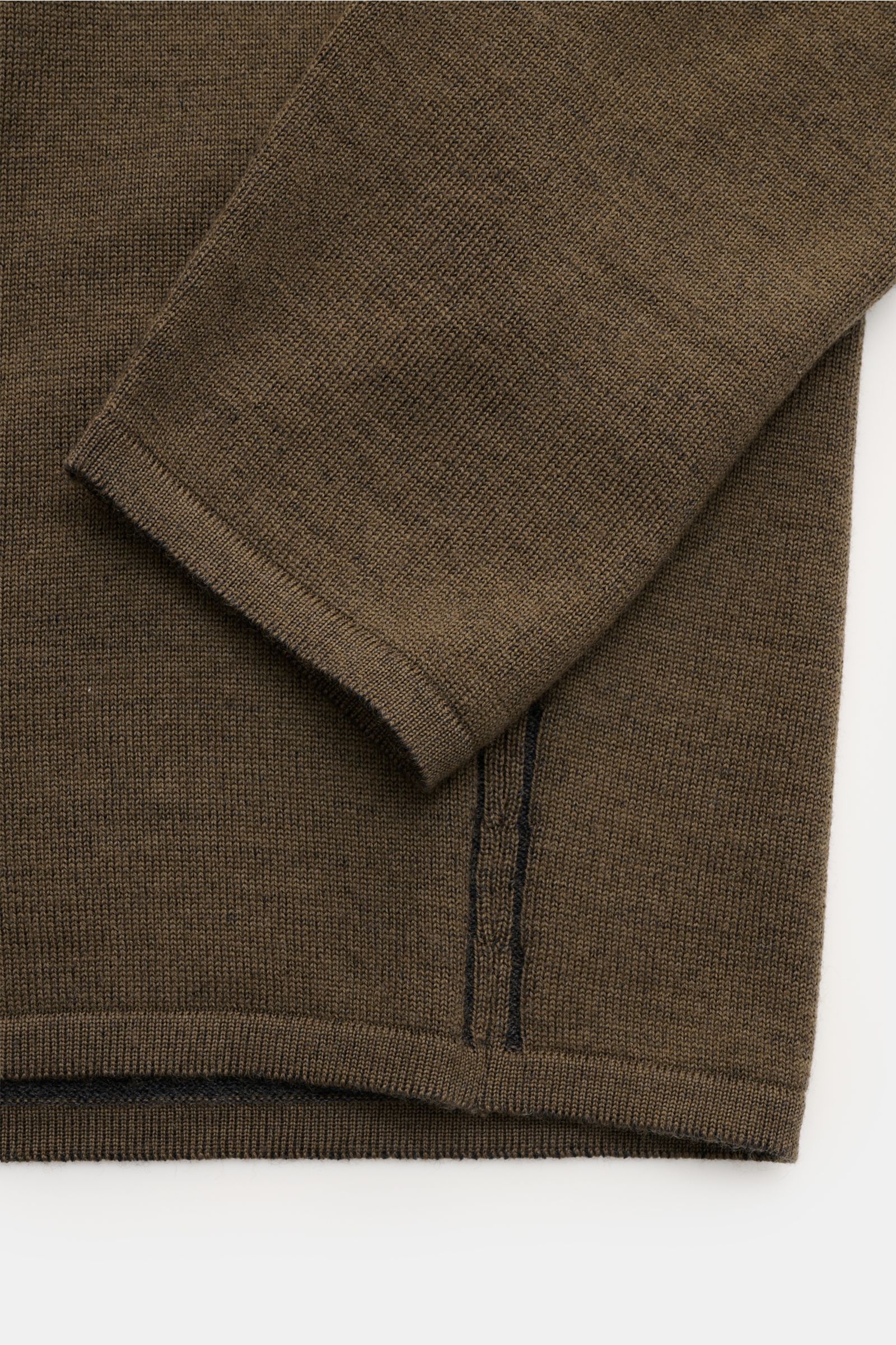 Close-up view of the sleeve and hem of the Kiefermann Merino Rundhalspullover 'Lutzs' khaki meliert, showcasing fine knit, contrast inner details, and double-stitched hems.

Update für ein Essential: Der Rundhalspullover von KIEFERMANN aus weicher Meri