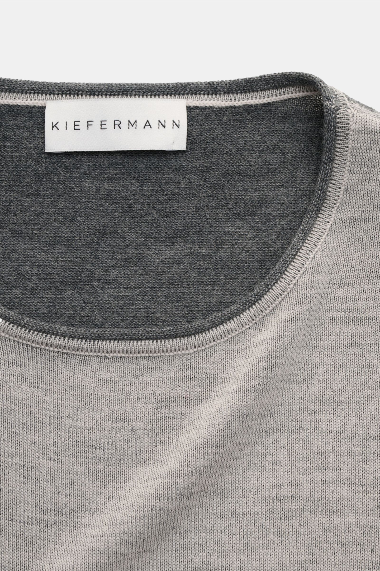 Close-up top-down view of Kiefermann Merino Rundhalspullover 'Lutzs' hellgrau meliert, showing soft, fine-knit merino wool with a two-tone yarn and contrast inner neckline.

Description: Update für ein Essential: Der Rundhalspullover von KIEFERMANN aus