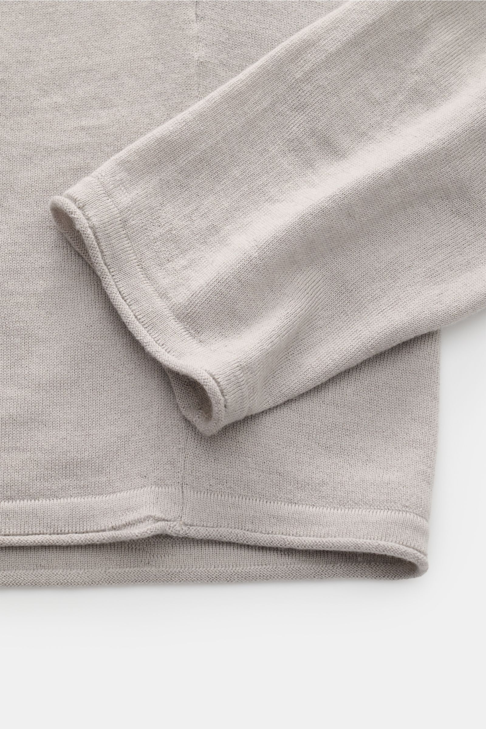 Close-up from above of the sleeve and hem of the Kiefermann Merino fine knit jumper 'Benjamin' light grey, featuring pure merino wool, super soft touch, very fine knit, slim fit, crew neck, and open, rolled hems.