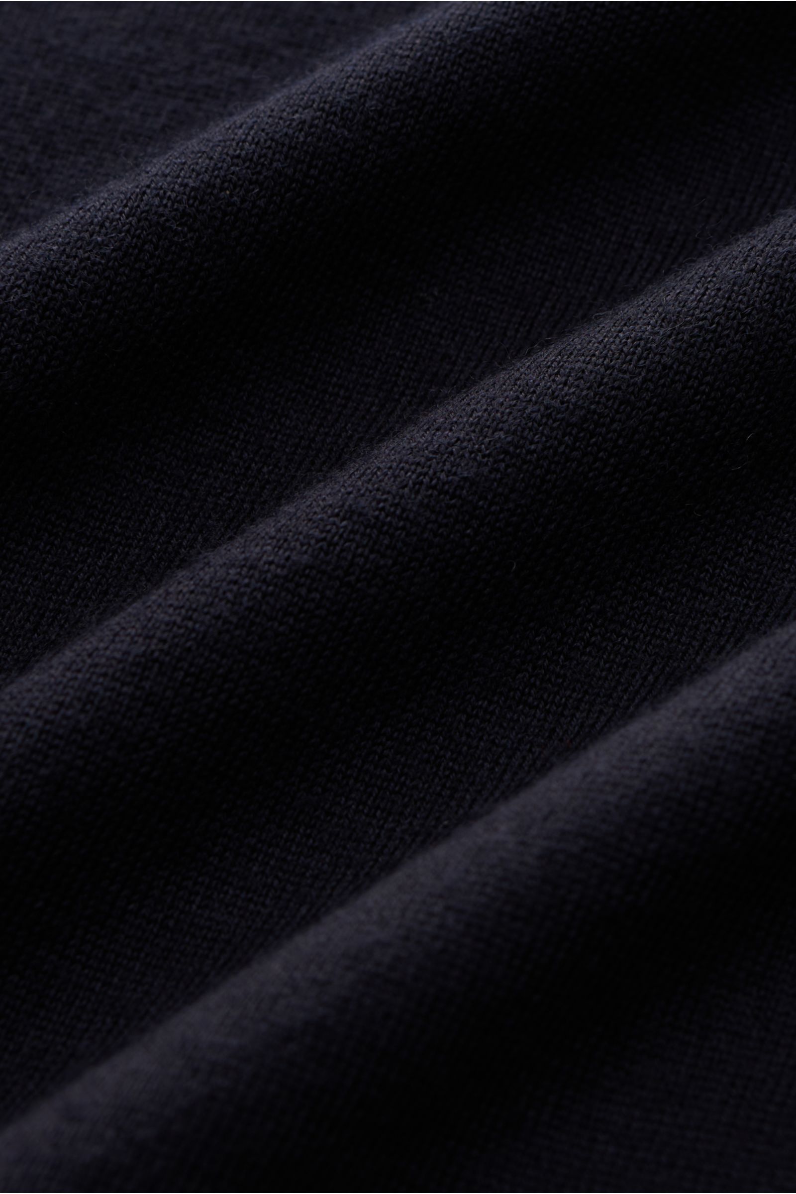Nahaufnahme des Kiefermann Merino Feinstrick-Pullover 'Benjaminn' navy, reine Merinowolle, superweicher Griff, sehr feines Strickbild, Slim Fit, Rundhalsausschnitt, offene, rollierte Kantenabschlüsse.