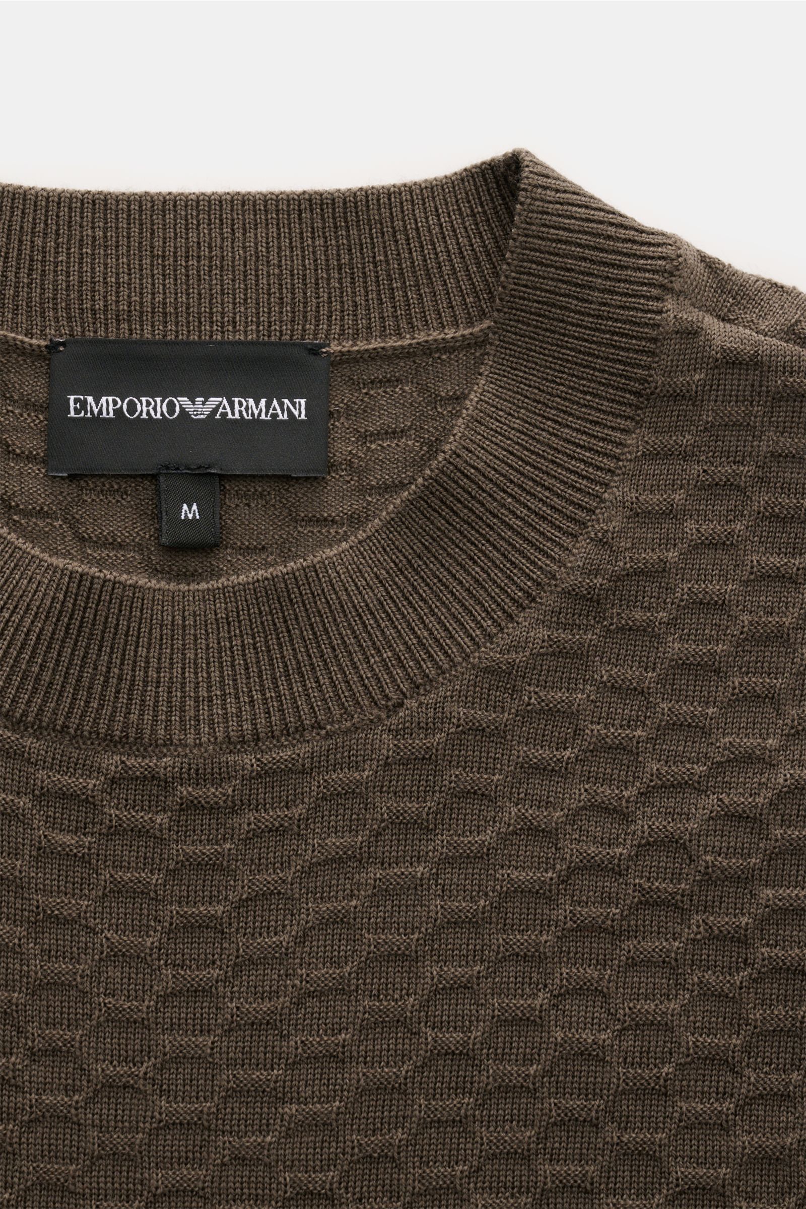 Emporio Armani Rundhalspullover graubraun aus reiner Schurwolle mit feinem Strukturstrick, Rundhalsausschnitt, Rippbündchen, Weblabel, Nahaufnahme von oben.