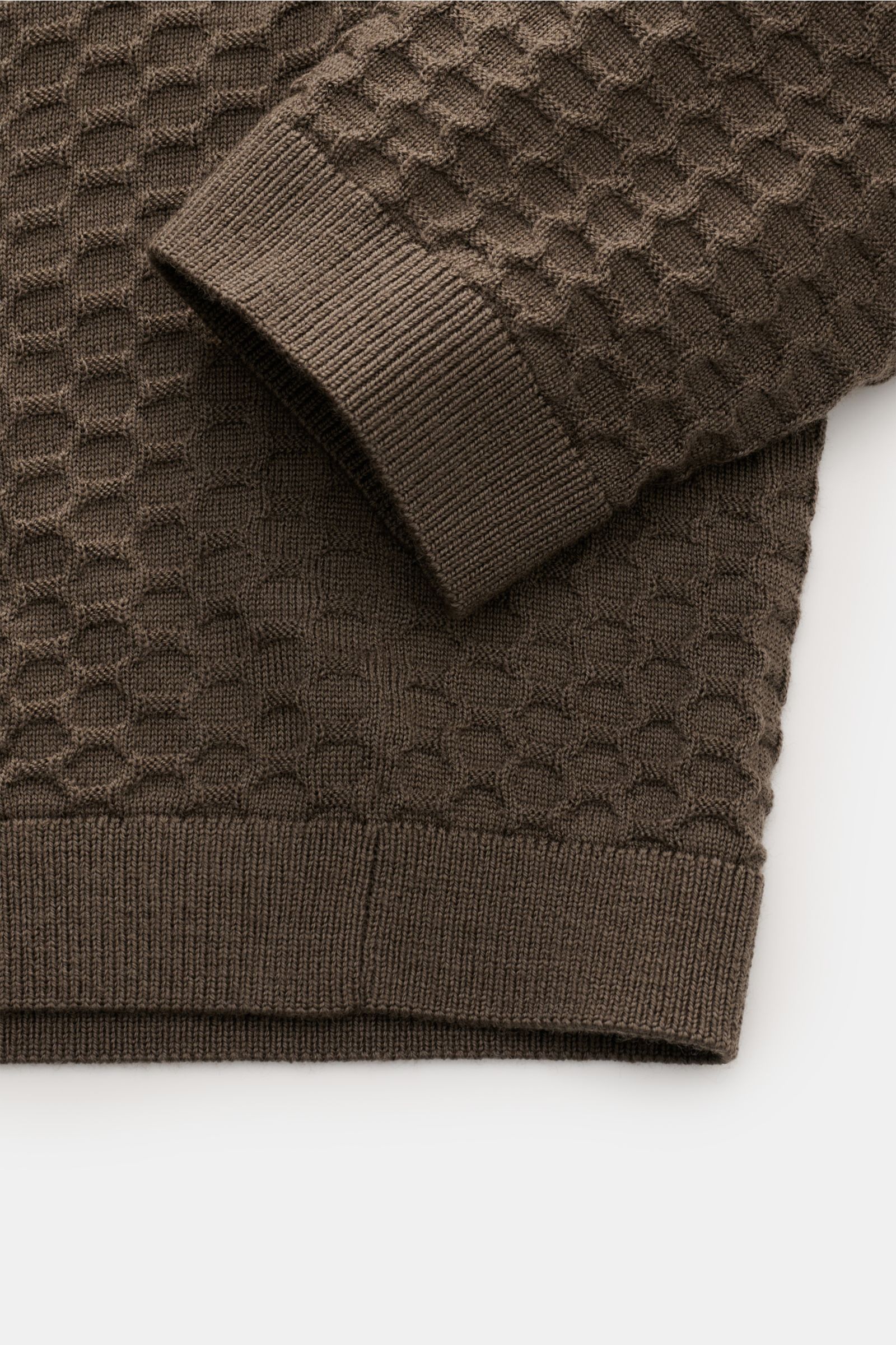 Emporio Armani Rundhalspullover graubraun aus reiner Schurwolle, feinem Strukturstrick, Rippbündchen, Detailfoto von Ärmel und Saum.