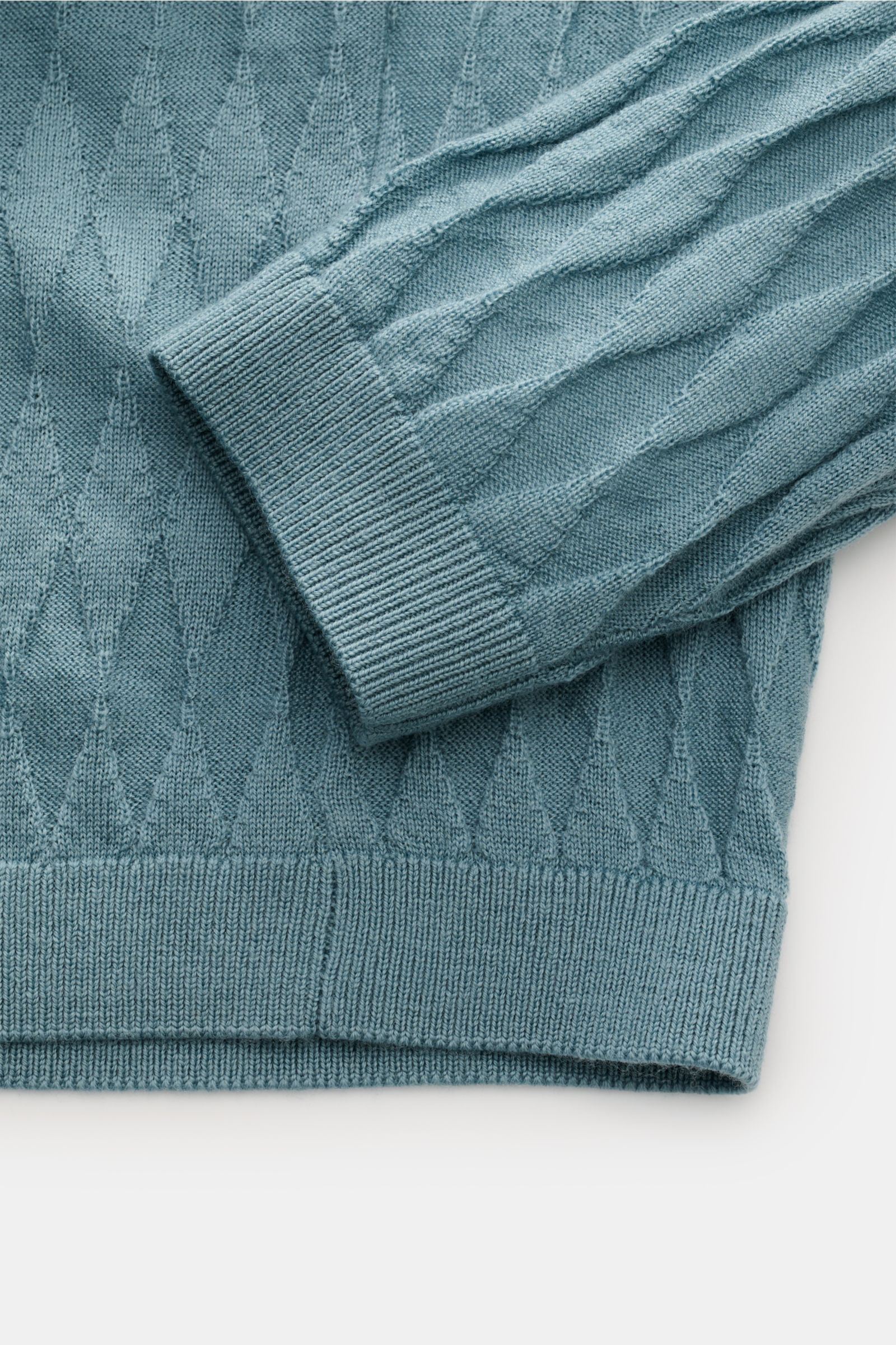 Emporio Armani Rundhalspullover rauchblau aus reiner Schurwolle mit Rautenmuster, Regular Fit, Rundhalsausschnitt, Rippbündchen, Detailaufnahme von Ärmel und Saum.