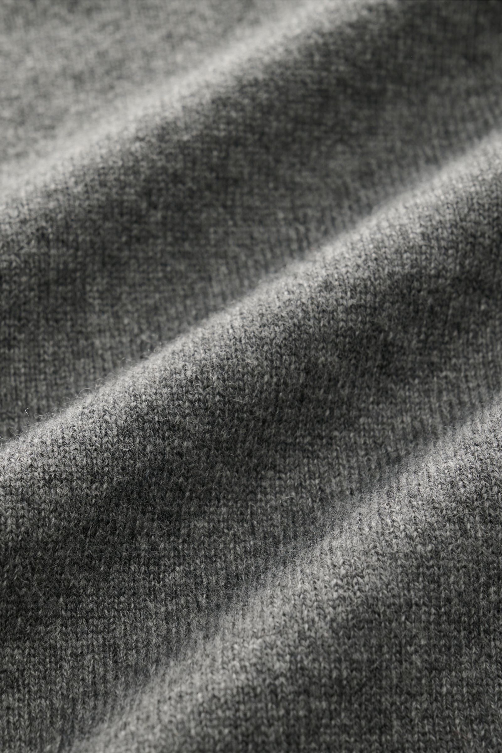 Close-up, angled view of the fine knit texture of the von Braun Rundhals-Pullover anthrazit, a soft mix of wool, viscose, and cashmere with a regular fit, round neckline, and comfortable ribbed cuffs, offering timeless style and pleasant wear comfort.
